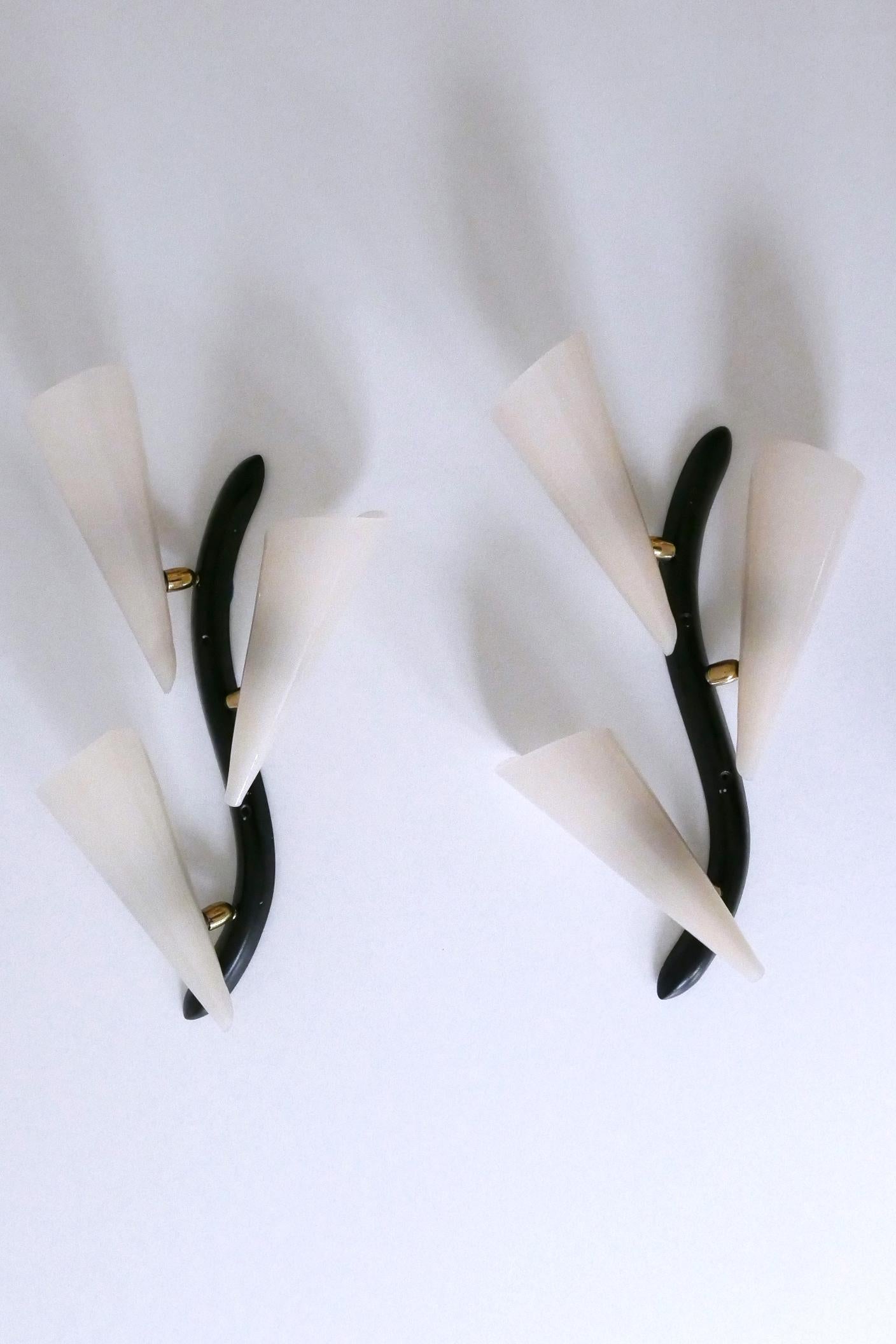 Set of two extremely rare, elegant and highly decorative Mid-Century Modern three-flamed sconces or wall fixtures. Designed and manufactured probably in Germany, 1950s.

Executed in lucite and cast aluminum, each sconce is executed with 3 x E14 /