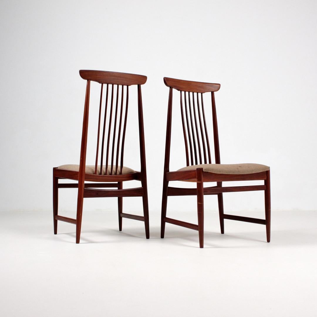 Pair of high-backed slatted chairs from the 1960s. Filigree construction made of solid wood, probably teak, upholstered seat made of plywood with covers made of light-colored fabric.
Dimensions approx. H. 100 cm, W. 49 cm, D. 54 cm.
The upholster