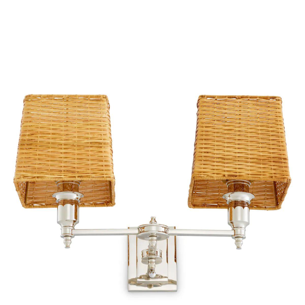 This double wall lamp in nickel finish is a refined lighting piece designed to bring balanced illumination and subtle elegance to contemporary or classic interiors. Featuring two natural rattan shades, the double wall lamp diffuses a warm, inviting