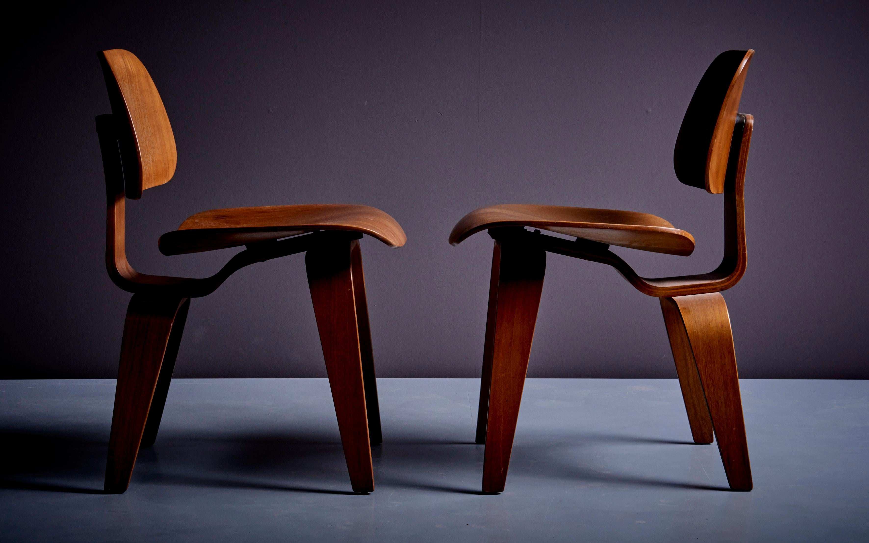 Jeu de deux chaises Eames DCWlounge en noyer pour Herman Miller, USA. La chaise DCW, également connue sous le nom de chaise de salle à manger en bois, est un meuble moderniste créé par l'équipe de designers mari et femme de Charles et Ray Eames en