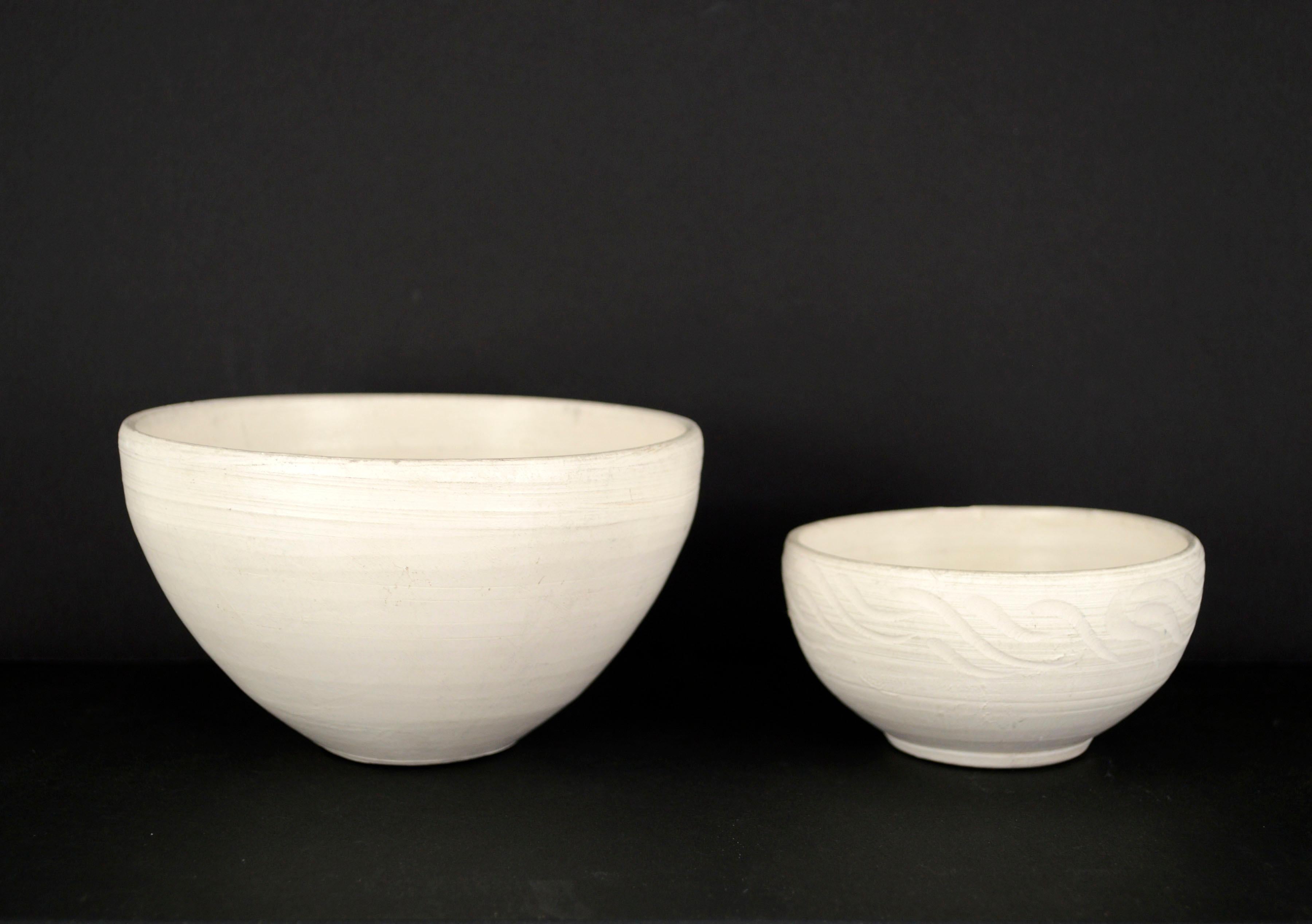 Set of two hand thrown mid-century pottery bowls by California artist Hamilton Achille Wolf (American, 1883 - 1967), 
these two bowls exemplify an organic modern aesthetic with a white matte finish, natural texture, and minimalist design. The