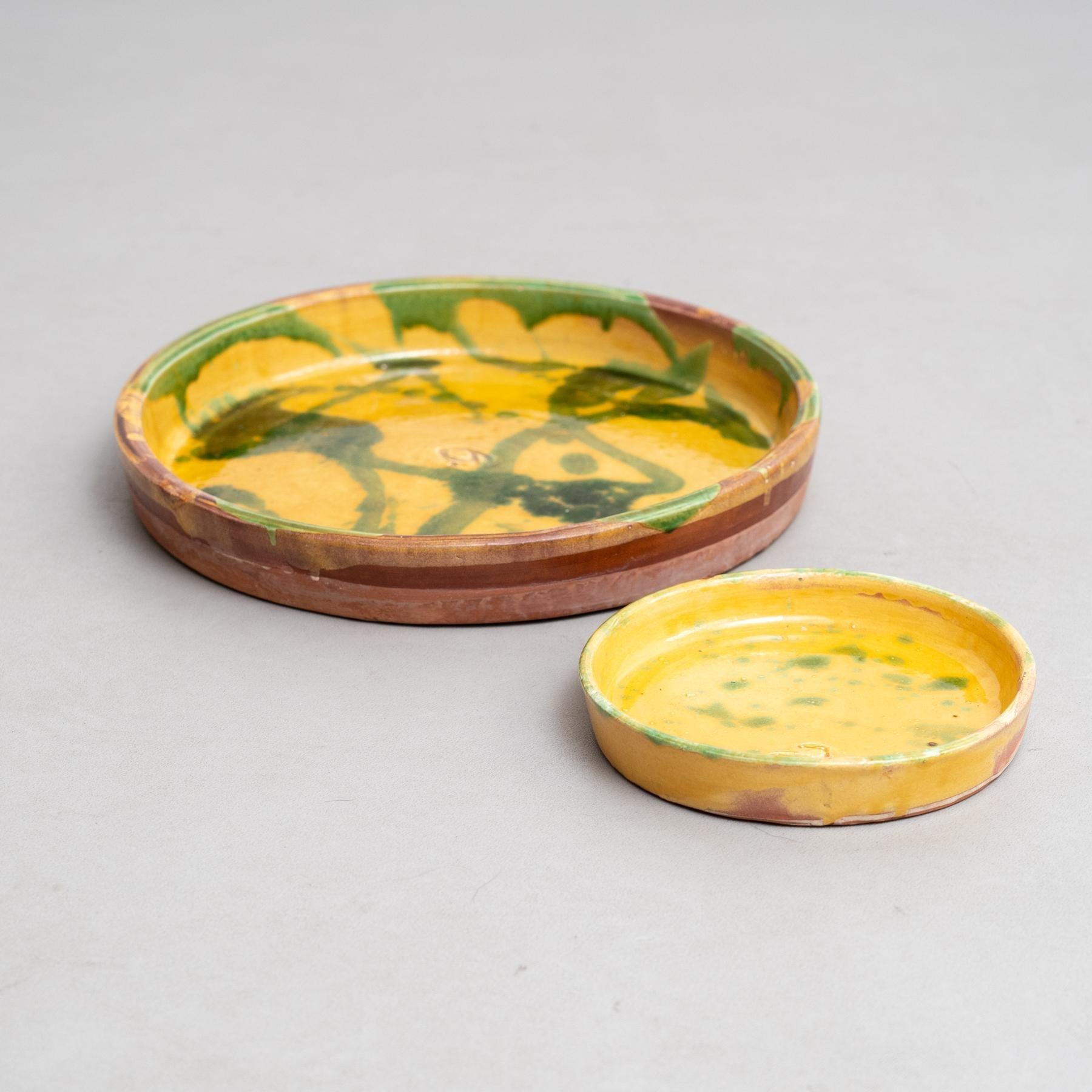 Dieses Set aus zwei gelben Keramiktellern mit charmanten grünen Sprenkeln erinnert an die traditionelle Volkskeramik des frühen 20. Jedes Stück, das sorgfältig von Hand bemalt wurde, spiegelt die Handwerkskunst eines unbekannten Kunsthandwerkers in