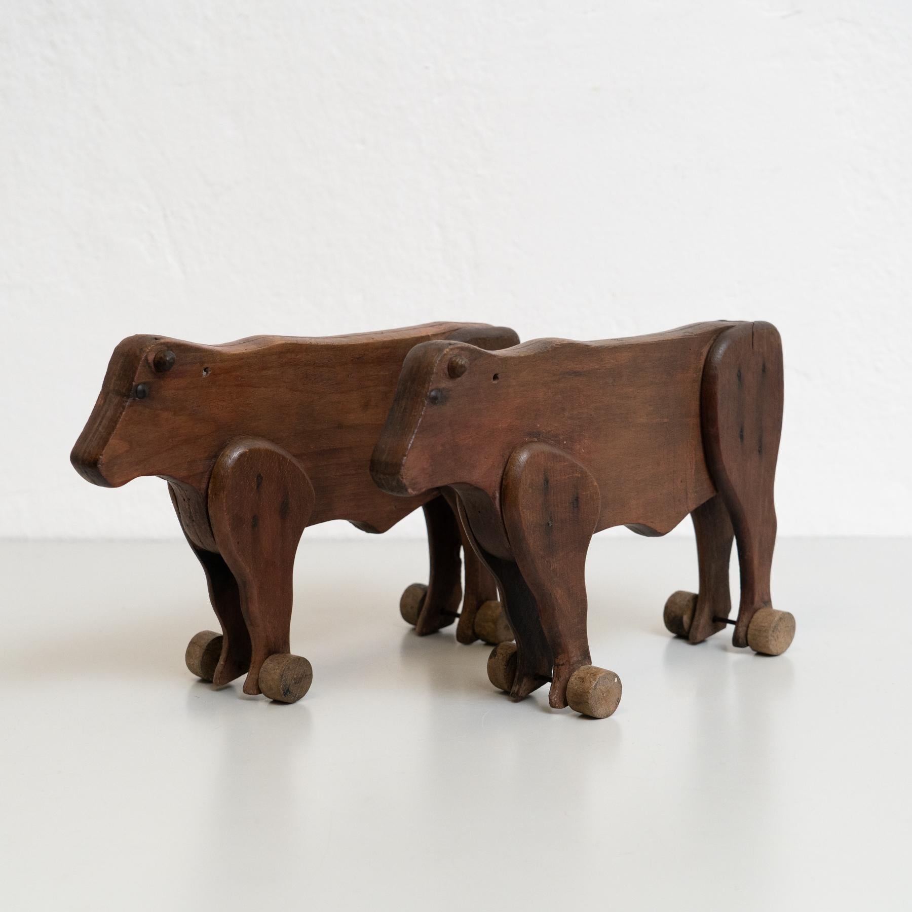 Satz von zwei rustikalen, traditionellen Kuh-Skulpturen aus Holz des frühen 20.
Hergestellt in Frankreich.

In ursprünglichem Zustand mit geringen Gebrauchsspuren, die dem Alter und dem Gebrauch entsprechen, wobei eine schöne Patina erhalten bleibt.