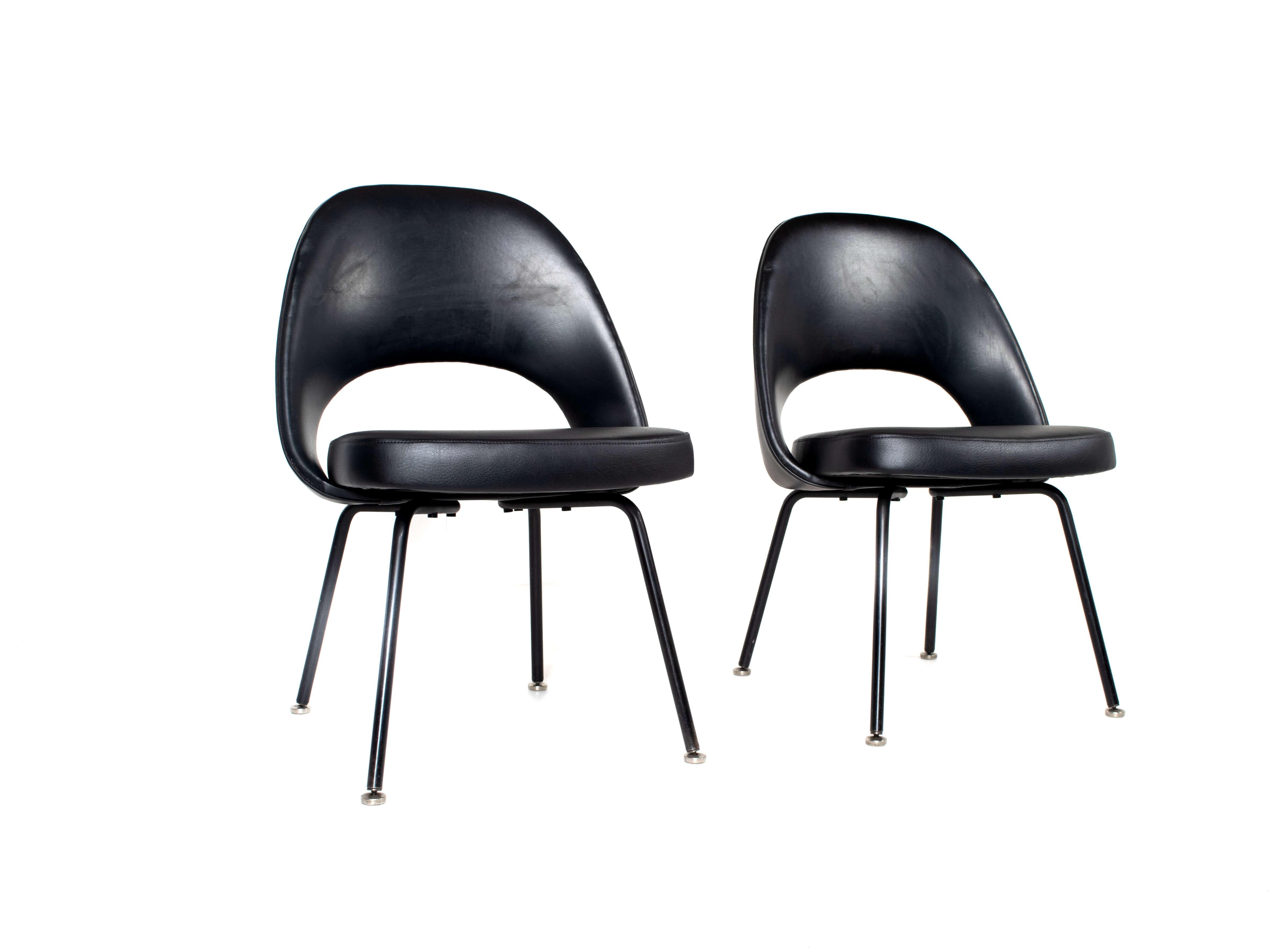 Set of two Eero Saarinen executive chairs for Knoll De Coene, Belgium 1950s. These chairs have black leather upholstery and black metal legs, finished with round feet. Both chairs are in good condition; one chair has a small dent in the leather as