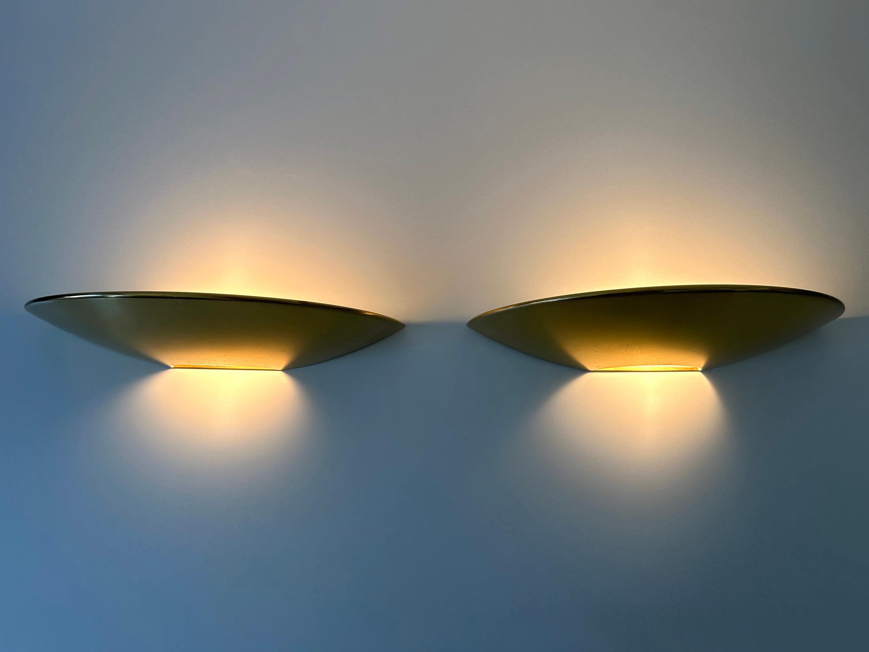 Set of two elegant Mid-Century Modern brass sconces or wall fixtures. Designed and manufactured by Florian Schulz, Germany, 1970s. 

Executed in polished brass, each sconce comes with 1 x E27 / E26 Edison screw fit bulb socket, is wired and in