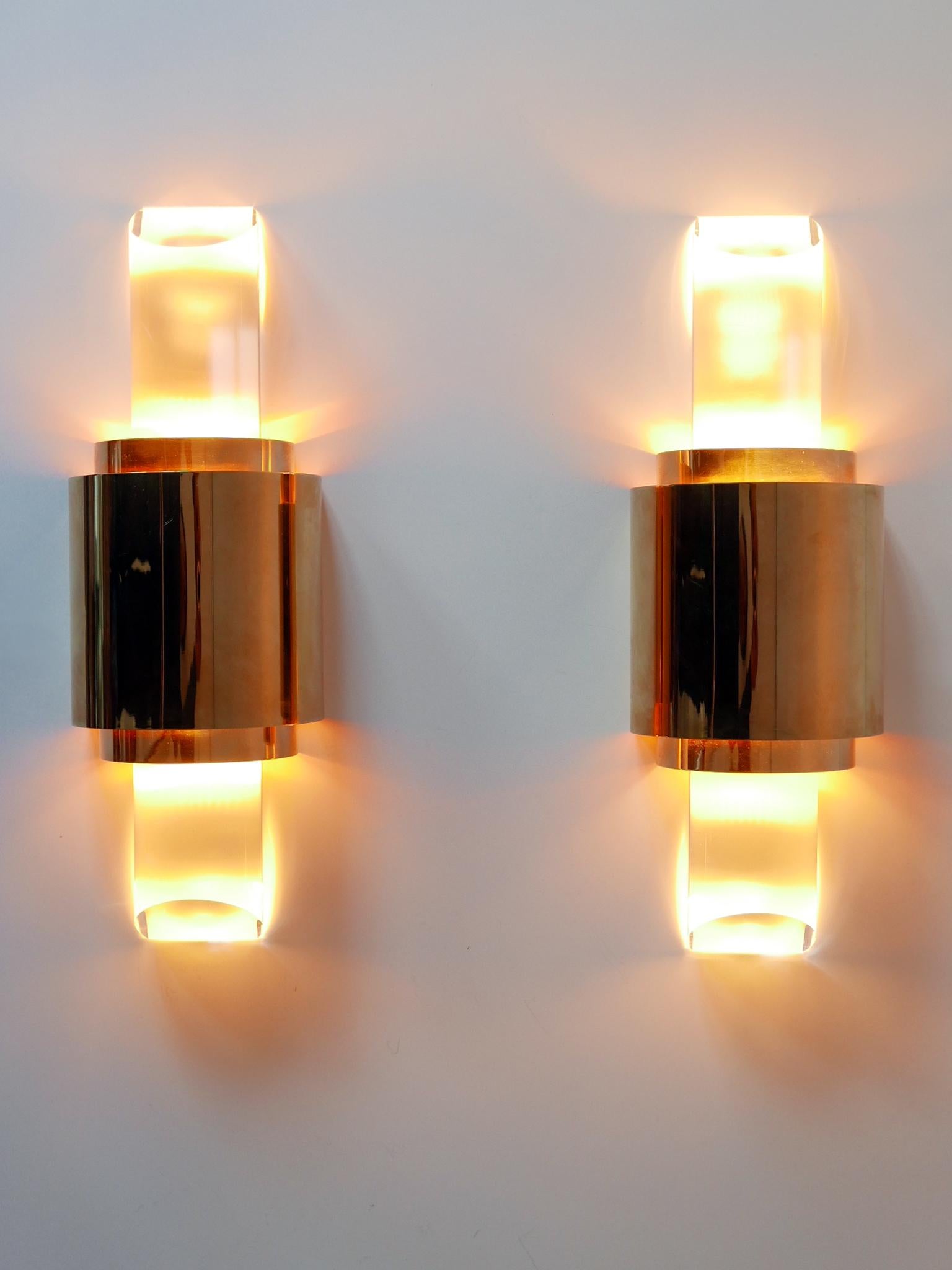 Set of two exceptional and elegant Mid-Century Modern gilt brass and lucite sconces or wall fixtures. Solid and high quality products. Designed & manufactured in Germany, 1980s.

Executed in gilt brass and lucite, each fixture needs 1 x R7 halogen /