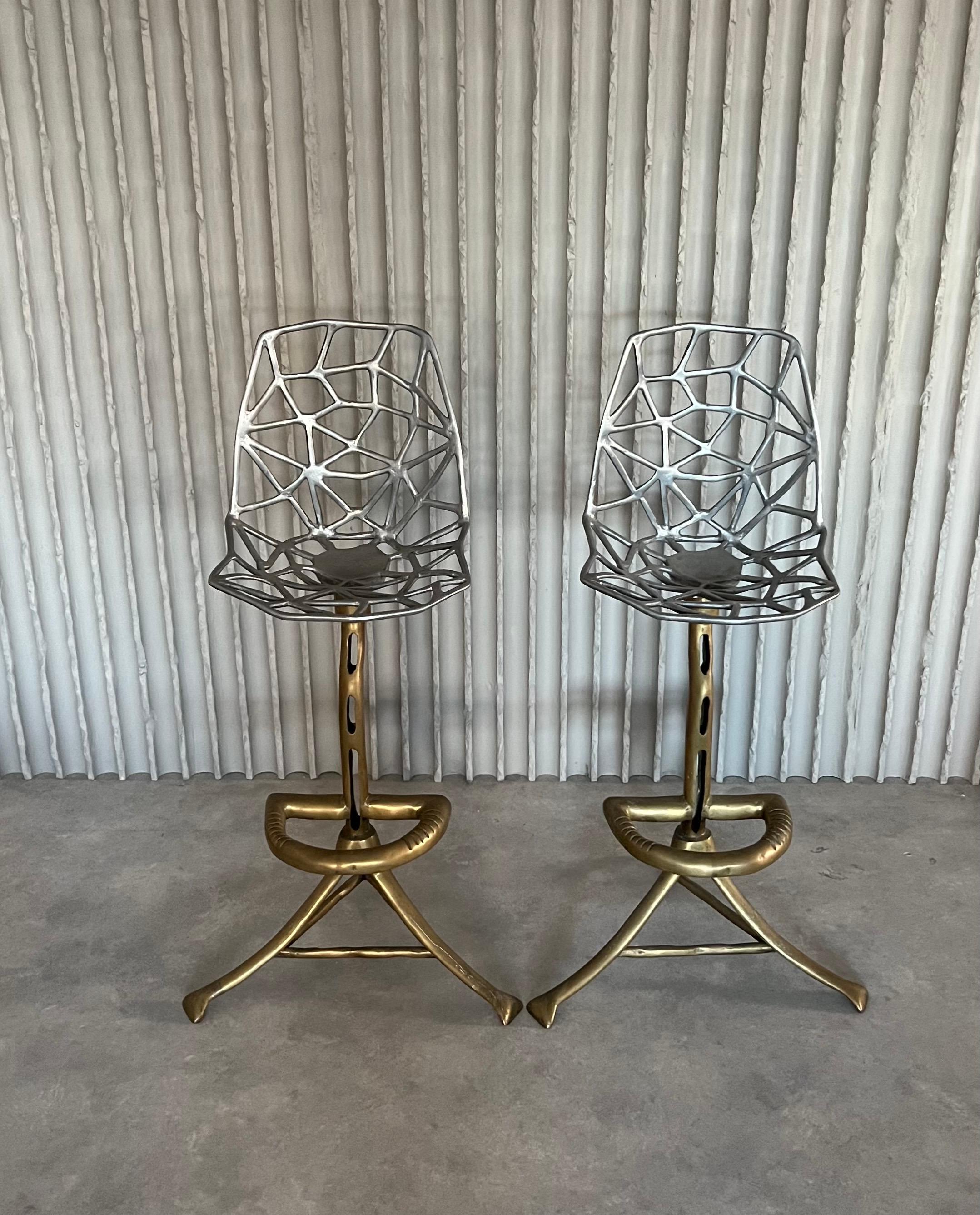 A pair of rare David Marshall, mixed metal stools. Composed of brass legs, foot rests, and stems. Finished with open work, aluminum seats along the tops. Spain, 1970s. Set price