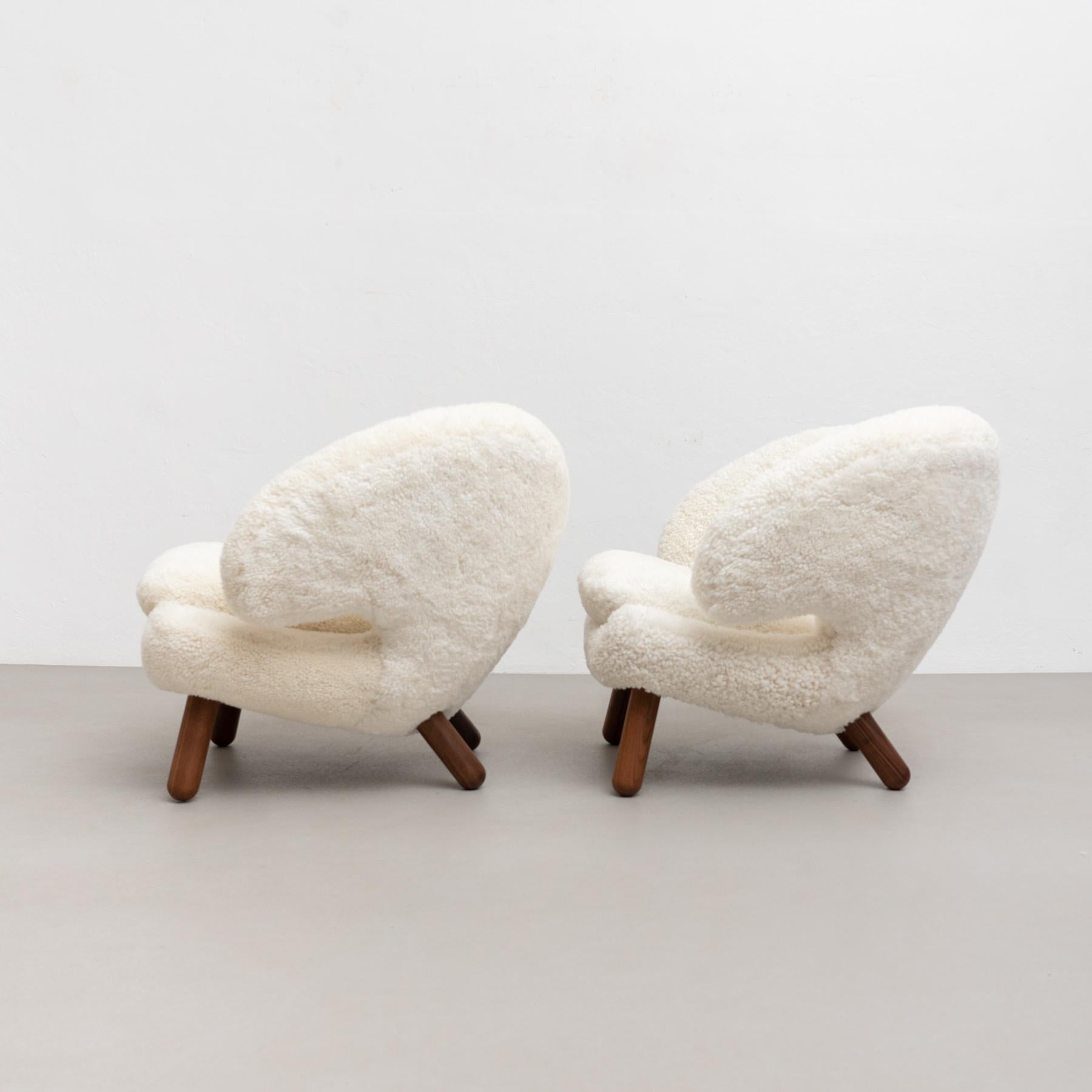 Tauchen Sie ein in die zeitlose Eleganz des Pelikan-Stuhls, einem Design-Meisterwerk von Finn Juhl aus dem Jahr 1940, das 2001 vom dänischen Haus Finn Juhls wieder in die Welt gebracht wurde. Gepolstert mit luxuriösem Gotland-Schafsfell ist jedes