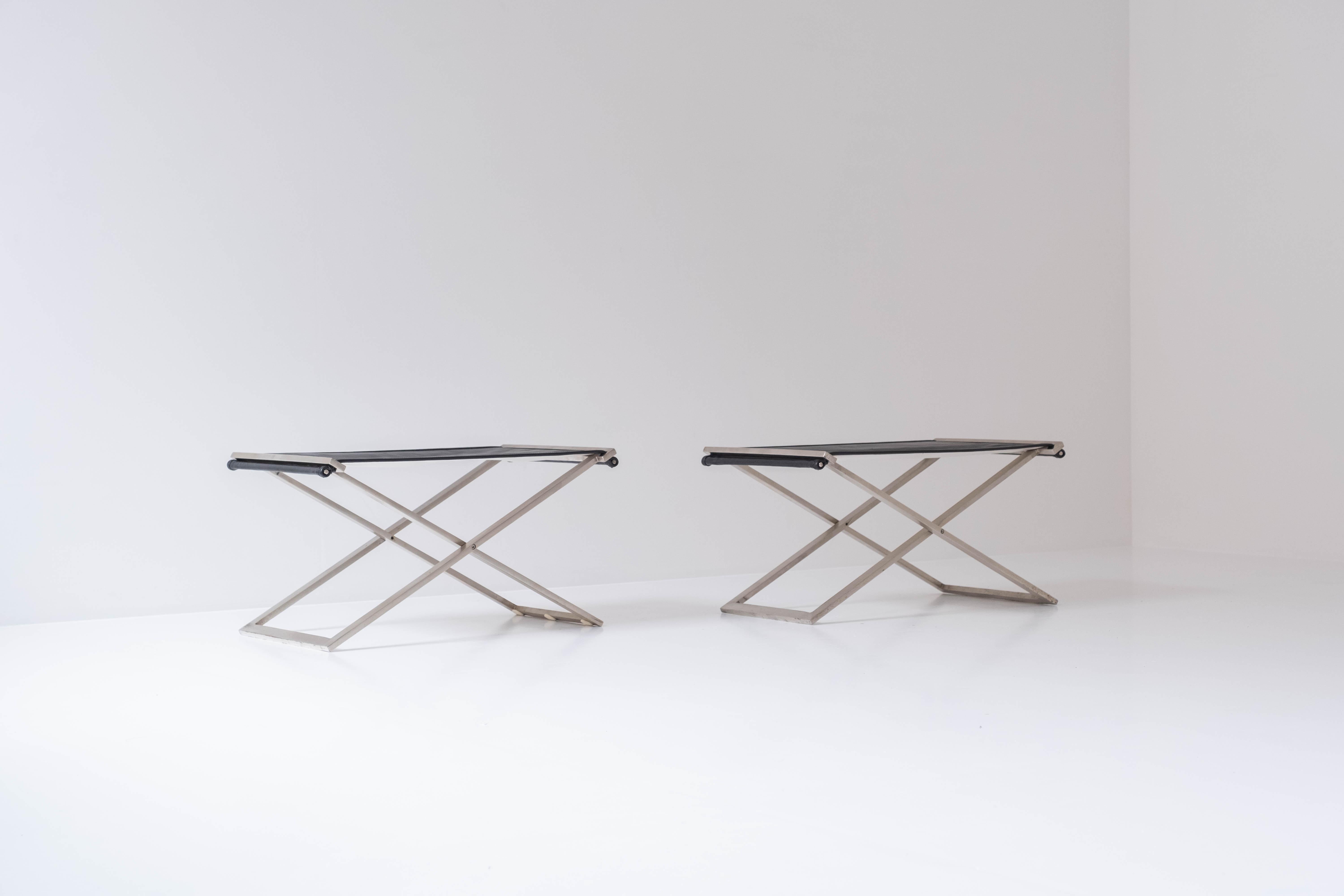 Set of two folding stools from Denmark, designed in the 1960s. These stools features steel frames and black leather seats. Professionally re-upholsterd in a high quality leather. Clearly inspired by the PK91 by Poul Kjaerholm.