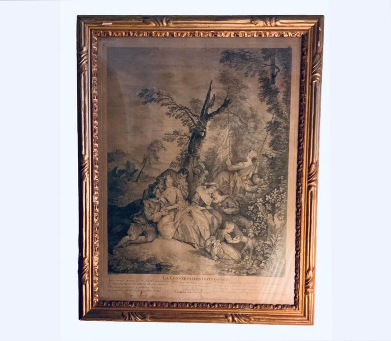 This is a set two framed French engraved art prints. The first one is titled “La Conversation Interessante”. It depicts an 18th century group of lover’s young couples sitting in a pastoral landscape and enjoying life. One of the young ladies is in a