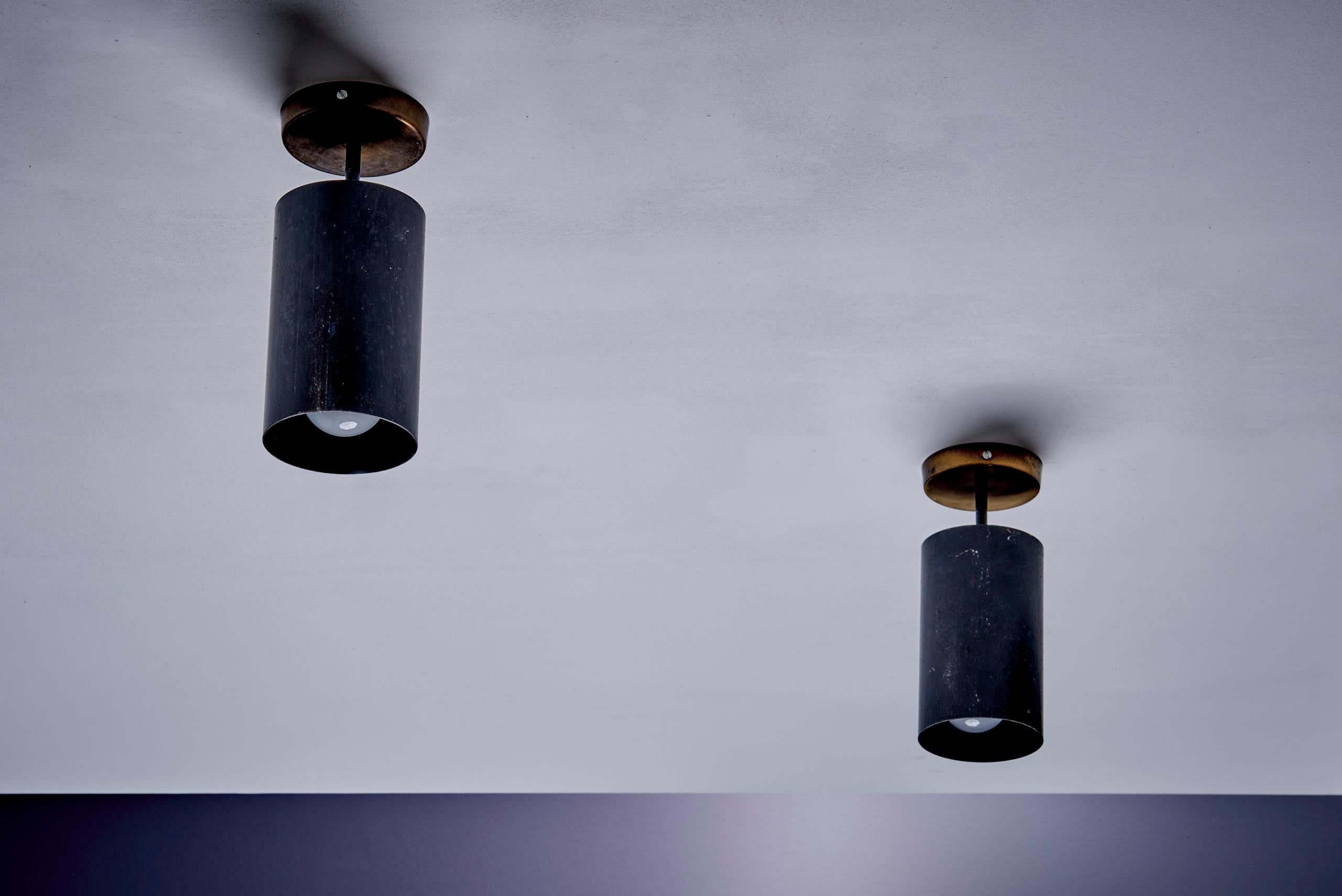 Paire de lampes cylindriques polyvalentes de Parscot, adaptées au montage au plafond. Canalisé en métal à la patine richement vieillie, chaque luminaire peut être orienté pour diriger la lumière. En état d'origine avec une usure authentique
