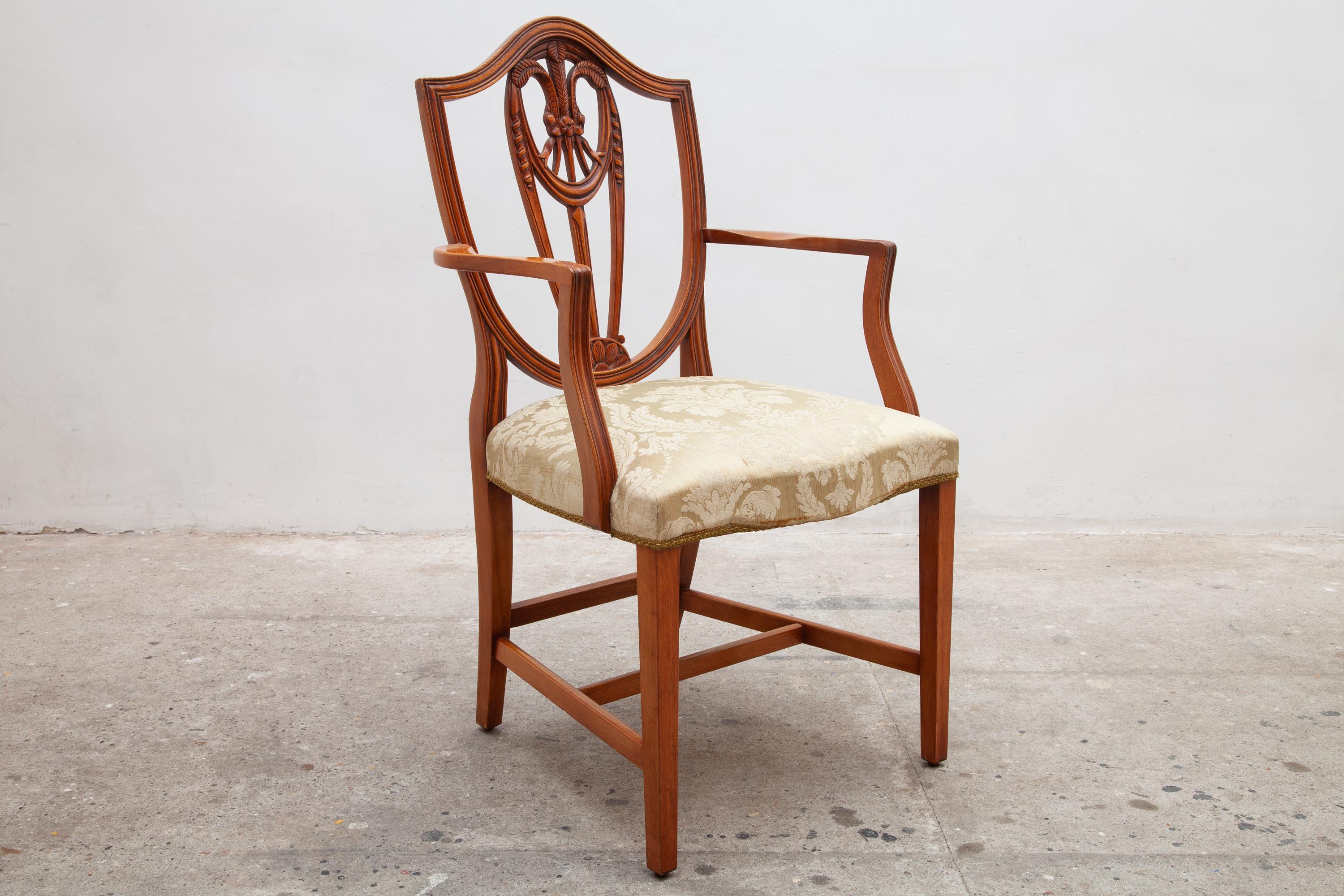 Un ensemble de deux chaises de style géorgien de haute qualité du 20e siècle. Cadre en noyer avec un arc sculpté et un motif floral au niveau du dossier, les sièges sont tapissés dans un matériau neutre de style damassé en excellent état.six chaises