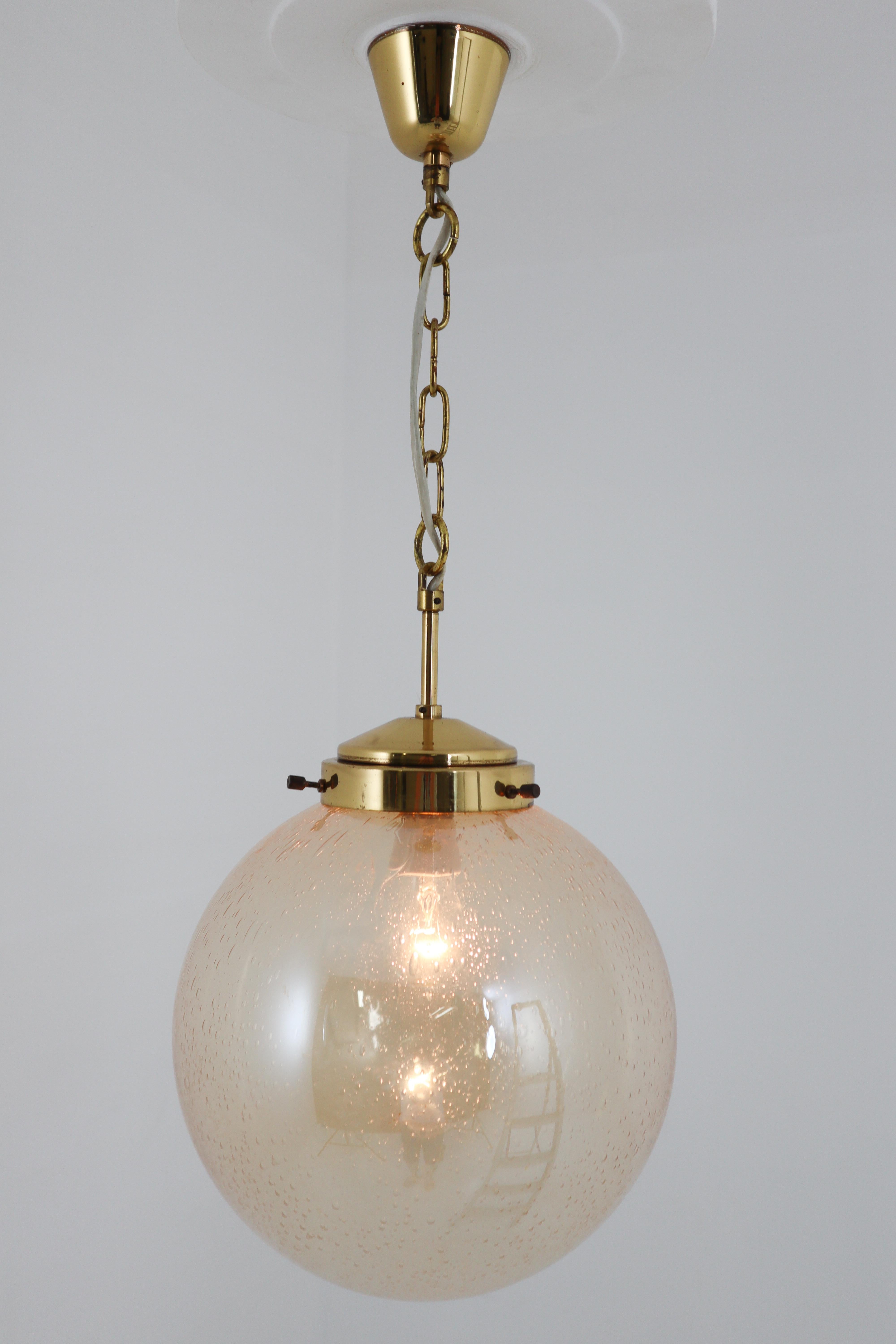 Set of two pendants, in colored glass and brass, Germany, 1970s.

Large globe shaped pendants with smoked glass spheres. The brass fixture beautifully combines with the smoked glass. Due their materials and size, these lights will create a beautiful