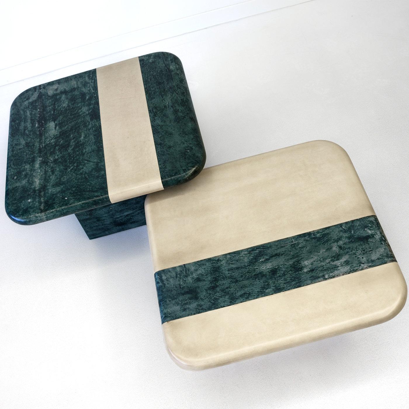 Réalisé avec une attention méticuleuse à la qualité et aux détails, cet ensemble de tables basses est défini par un plateau carré décoré du même motif géométrique en couleurs inversées : bleu-vert avec bande sable pour la version haute (80 X 80 X