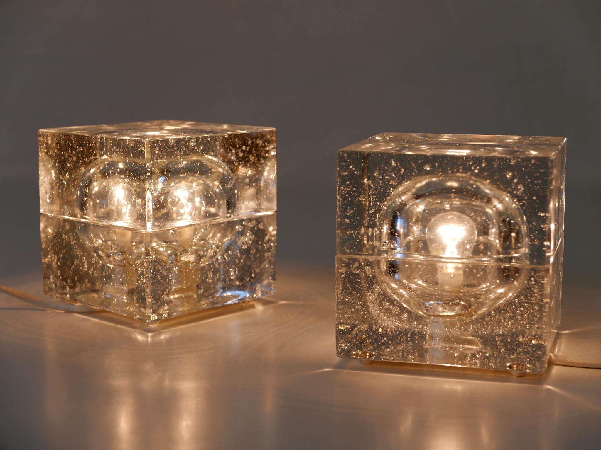 Ensemble de deux élégantes lampes de table en verre soufflé à la main dans le style Cubo Sfera d'Allessandro Mendini. Celles-ci sont conçues et fabriquées par Müller & Zimmer dans les années 1970, à Stuttgart, en Allemagne.

Réalisée en verre épais