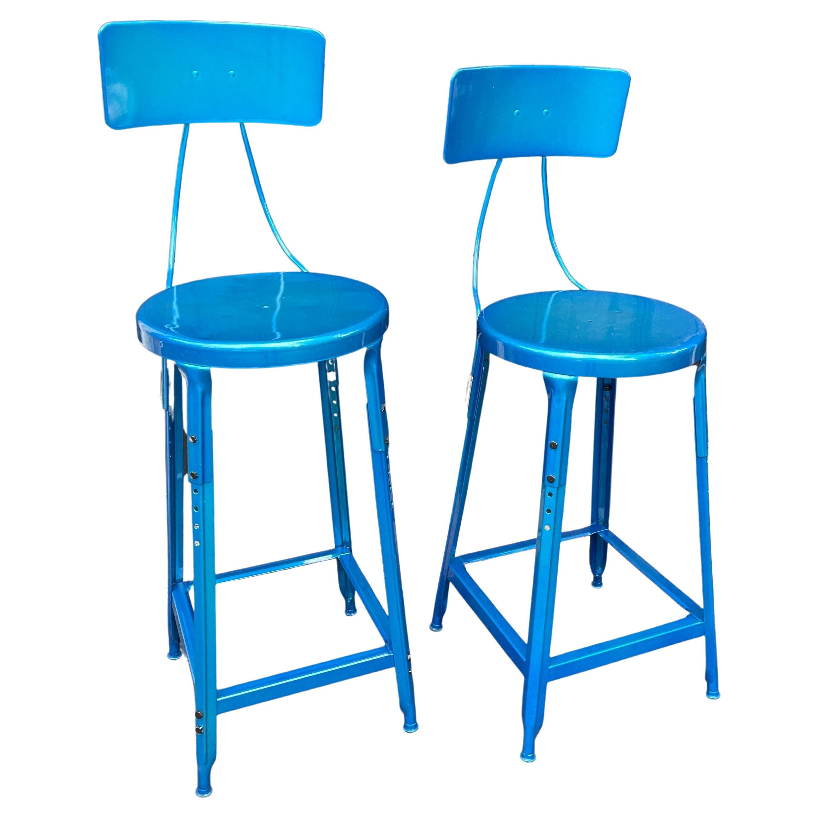 Set of Two Heavy Industrial metal bar stools with backs in Newly Powder Coated Maui Blue.
The chairs are not an even pair in height:
The smaller bar stool measures: 
Height of back is 39.5 inches
Width is 15 inches
Seat height 25.24
