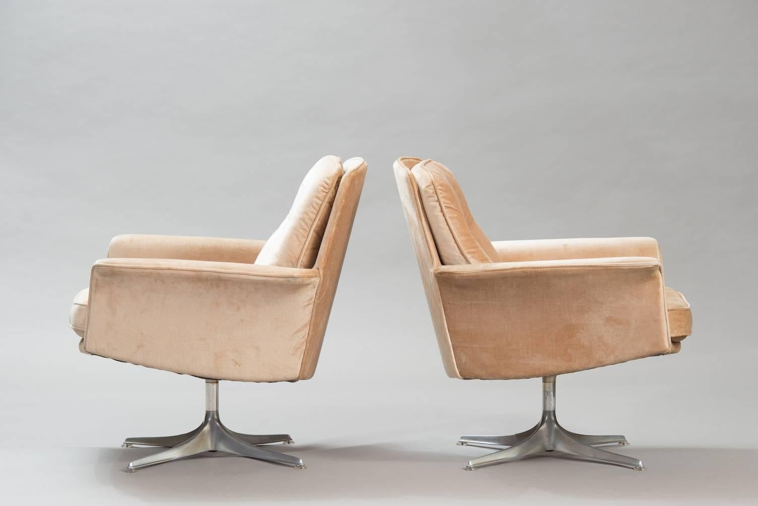 Set of two swivel lounge chairs upholstered in beige velvet in an aluminium base.
