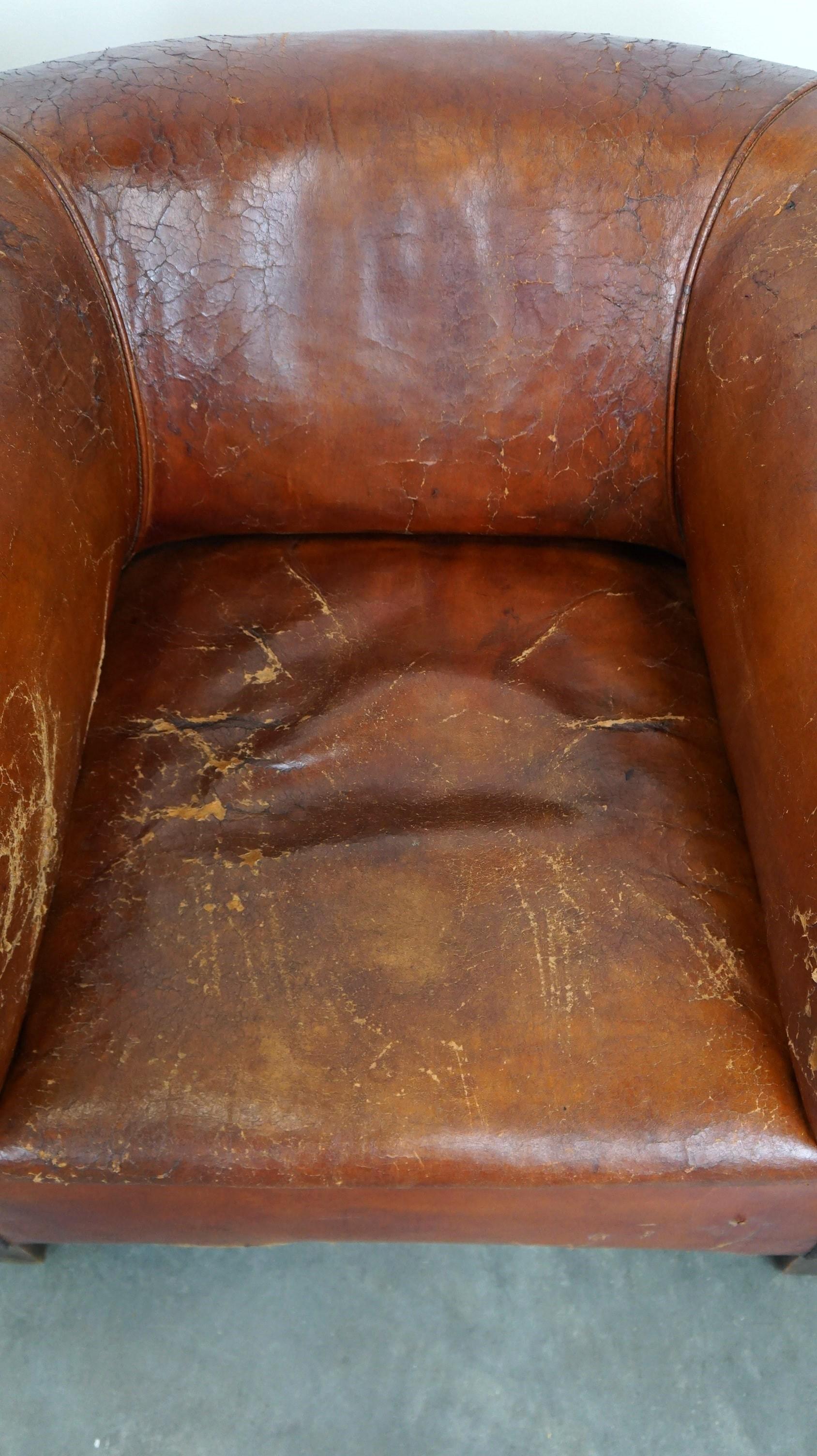Set of two incredible antique leather club armchairs, boasting a stunning patina In Distressed Condition For Sale In Harderwijk, NL