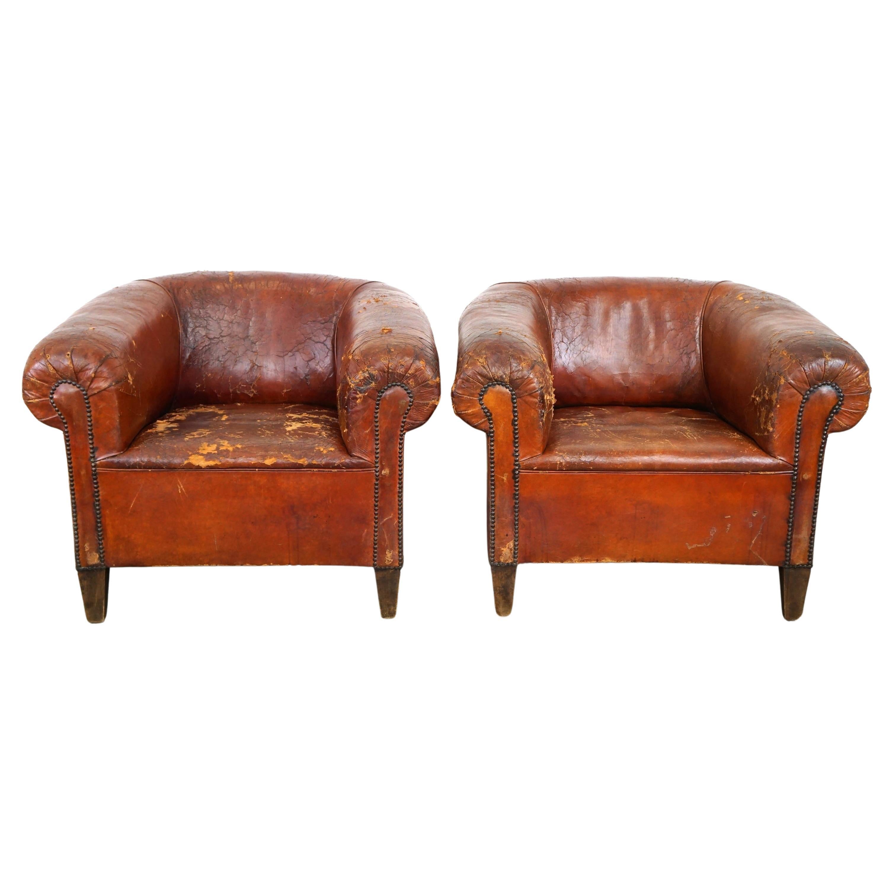 Set of two incredible antique leather club armchairs, boasting a stunning patina For Sale