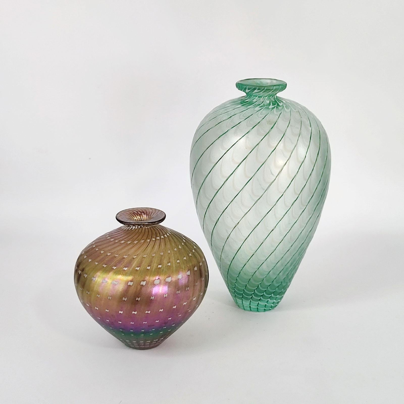 Ensemble de deux vases sculpturaux en verre irisé et métallique
Rarement associés à la série Minos de Bertil Vallien pour Kosta Boda, ces deux vases soufflés à la main en 1984 illustrent l'approche poétique du maître suédois en matière de forme, de
