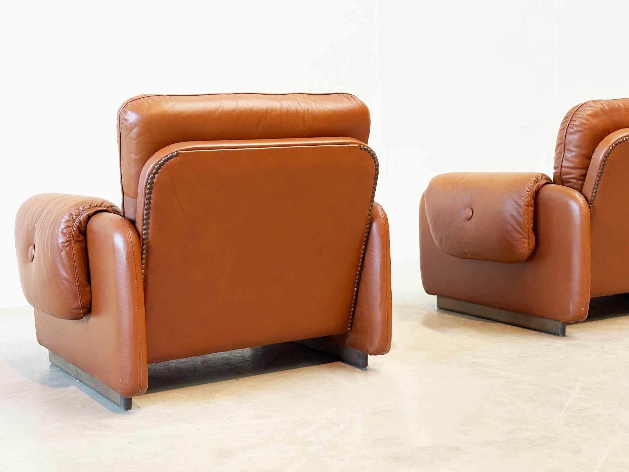 Set aus zwei italienischen cognacfarbenen Leder-Loungesesseln
Diese italienischen Loungesessel aus den 1970er Jahren sind mit reichhaltigem cognacfarbenem Leder ausgestattet und weisen die für italienisches Design typischen, eleganten Linien auf.