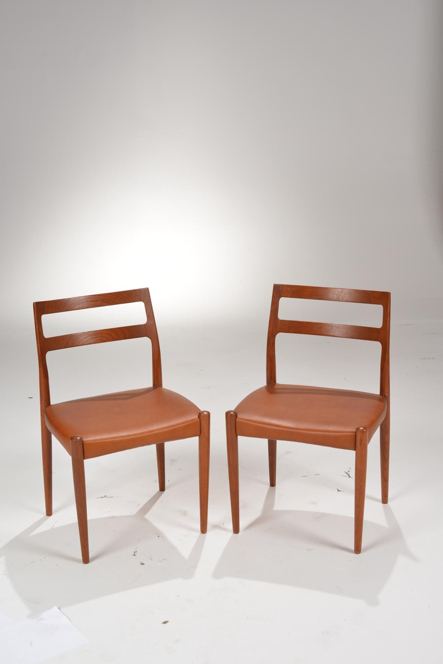 Set of two Danish modern dining chairs by Johannes Andersen for Uldum Møbelfabrik, sculpted from teak with new leather upholstery, and in the style of Niels Otto Moller.