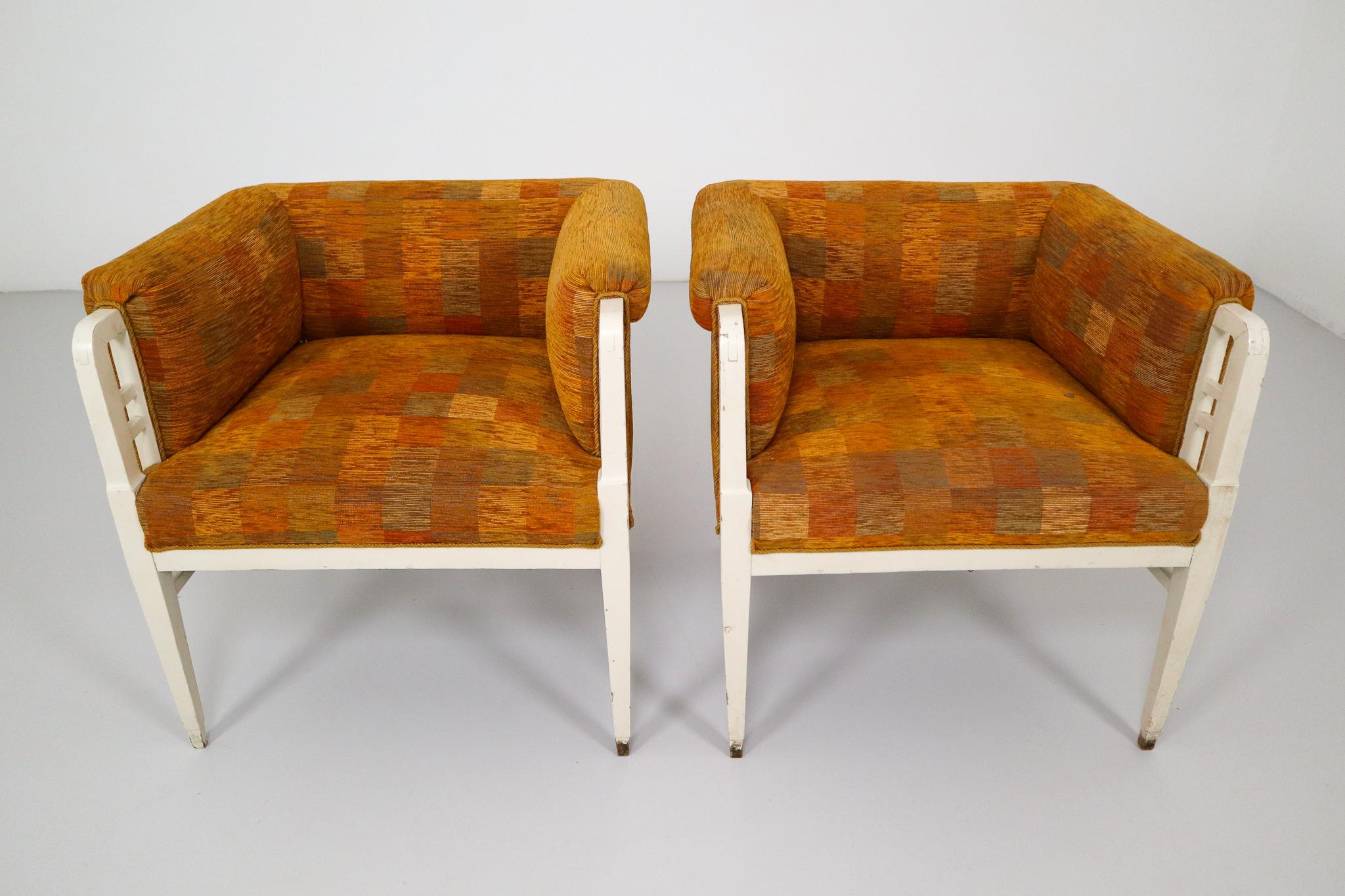 This is a set of two armchairs in the style of Jugenstil. It's made of white painted wood and an orange fabric. The upholstery can be replaced, ask us for more information about the possibilities we can offer.