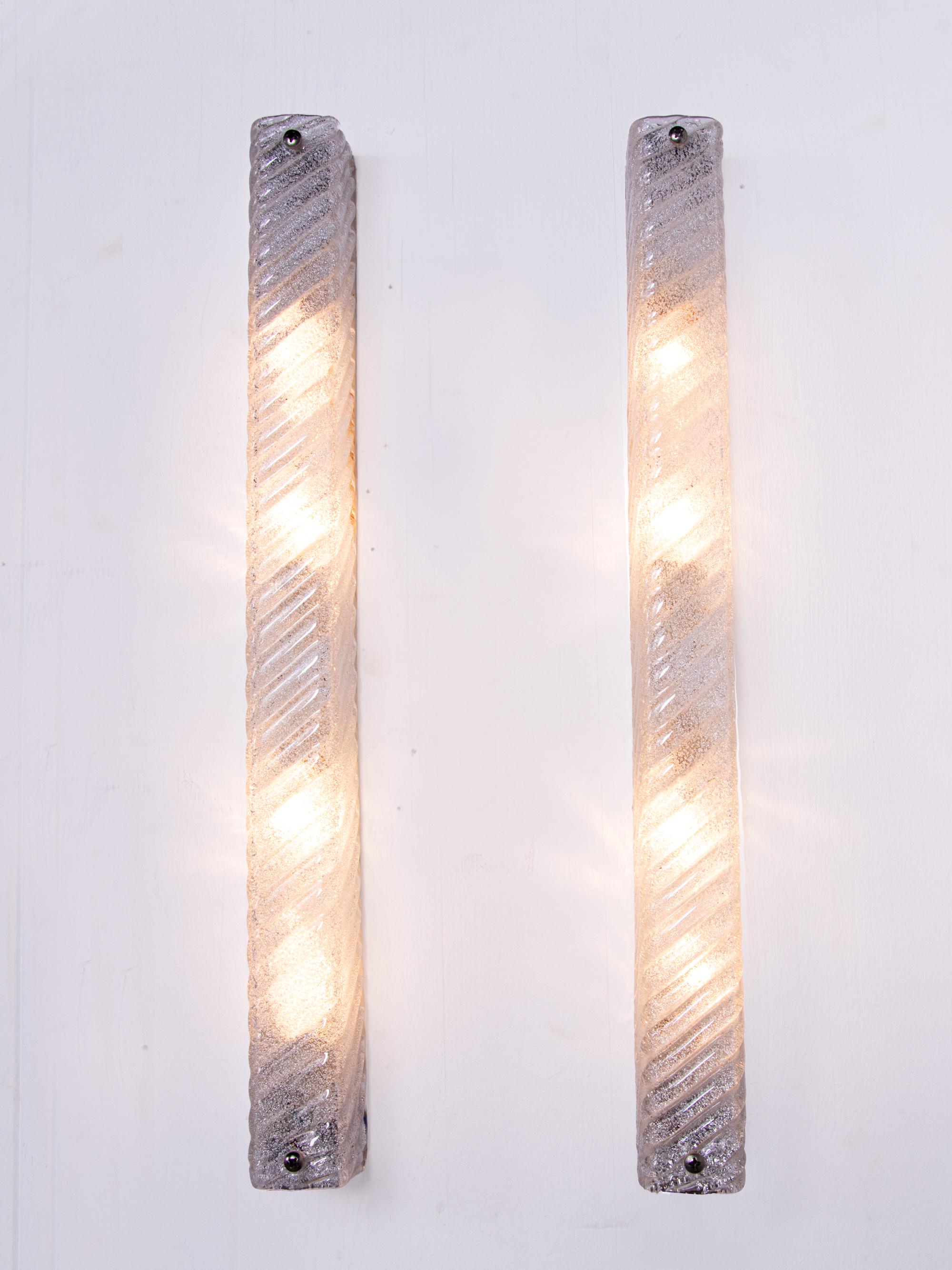 Elegant set of two large mirror wall sconces made of heavy, thick hand blown textured Murano glass on a metal frame. Gem from the time. With these lights, you can make a clear statement in your interior design. A real eye-catcher even unlit. 
