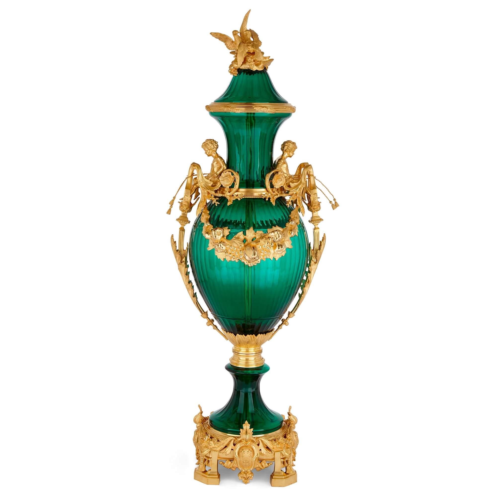 Set of two large green glass gilt bronze mounted vases
French, 20th Century
Height 153cm, width 50cm, depth 53cm 

Pairing gilt bronze with striped green glass, these grand French vases exude the elegance of Neoclassical design, subtly touched by