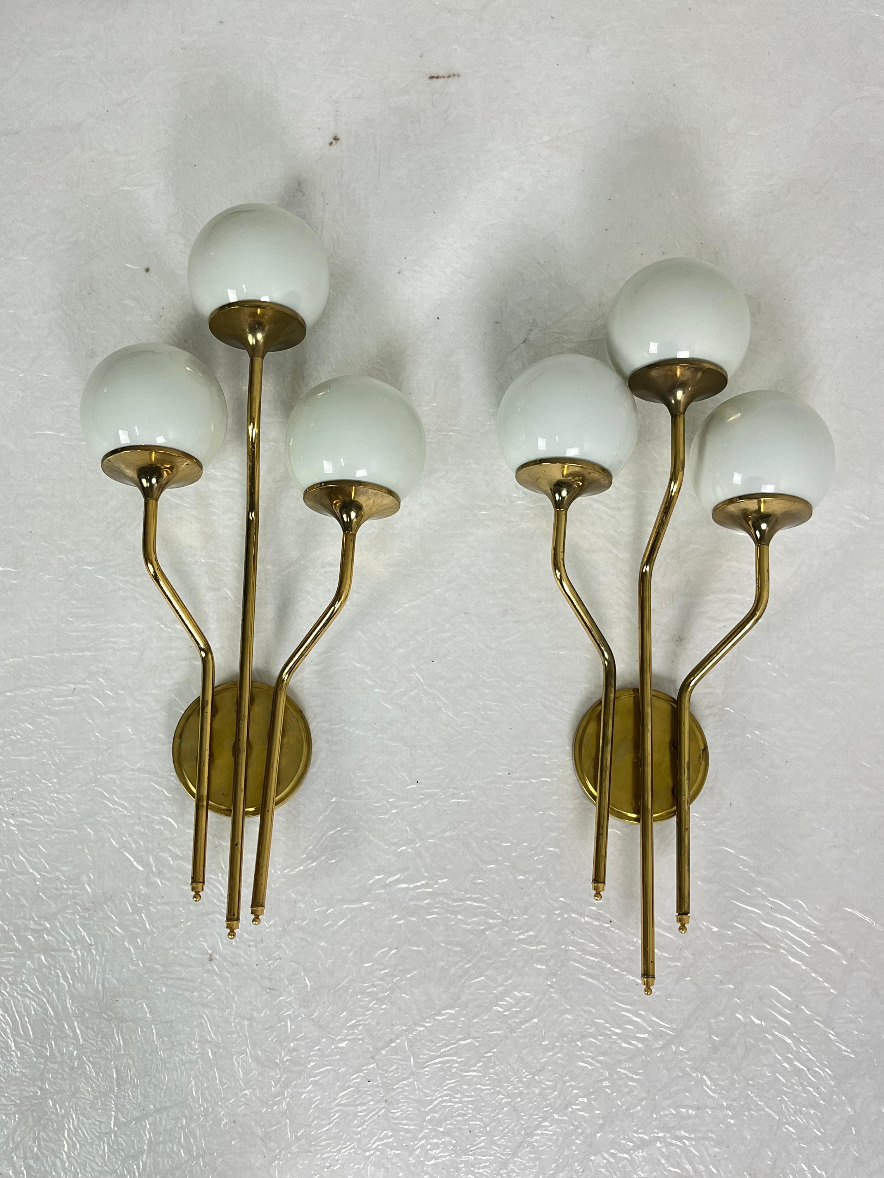Set di due grandi lampade da parete della met�à del secolo scorso attribuite a Stilnovo, anni '60.
Struttura in ottone e ciotole in vetro opalino.
Lampadine a 3 luci, E14.
Vetro intatto.
Buone condizioni.
Trovato in un appartamento della mia città