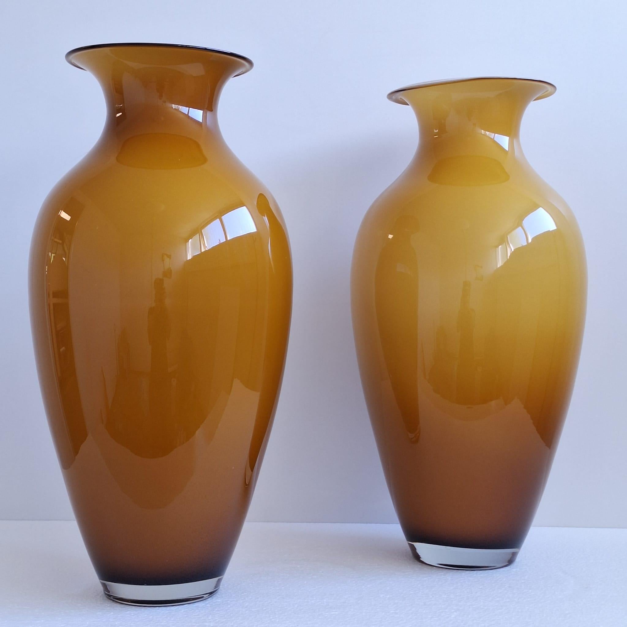 Set di due grandi vasi di Murano degli anni '60. I vasi sono realizzati in vetro soffiato e incapsulato (giallo ambrato all'esterno e bianco latte all'interno). Il ricco colore ambrato, che ricorda i tramonti dorati e le calde tonalità autunnali,