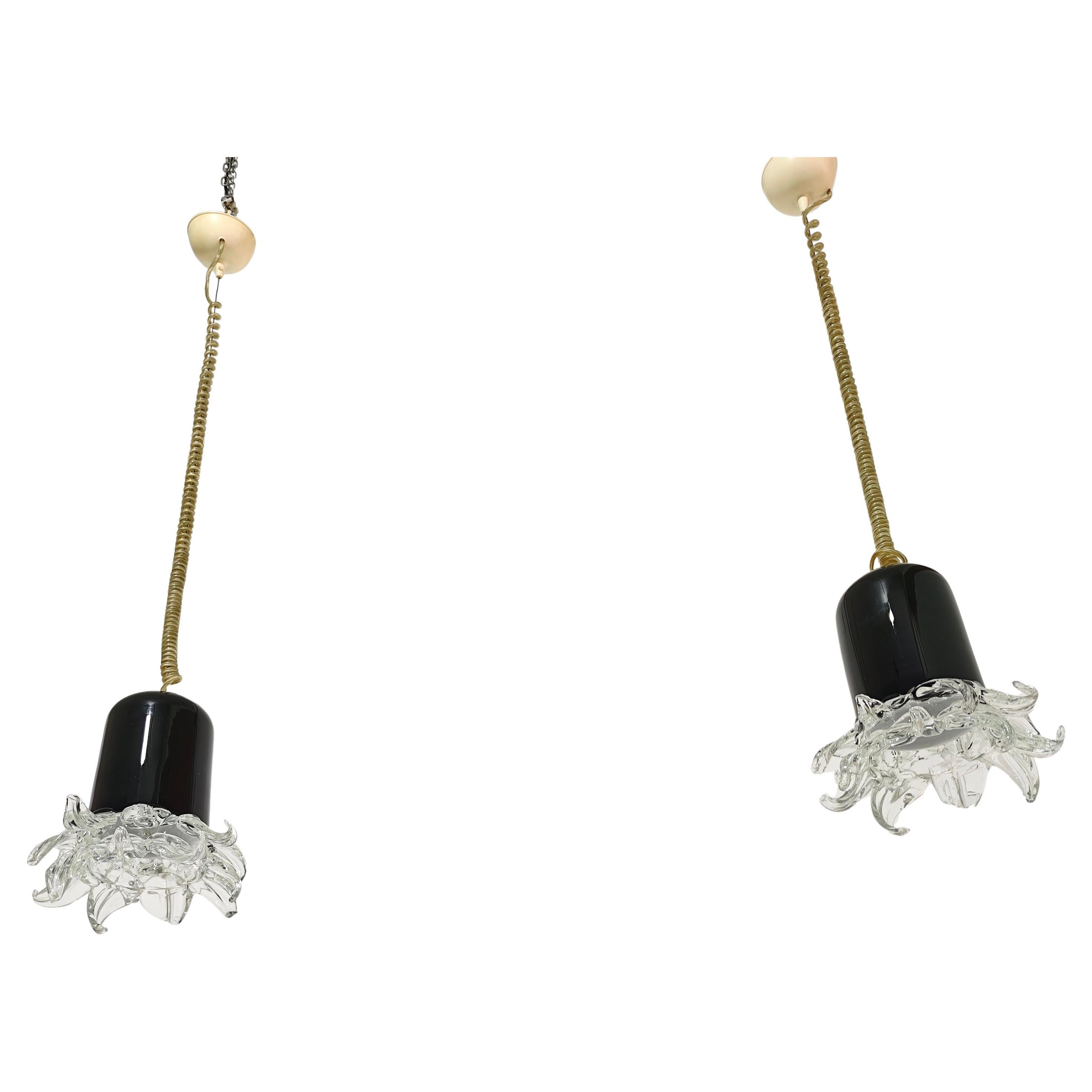Leucos Made in Murano, Italia, circa 1970
Set di due lampade a sospensione a una luce, con diffusore cilindrico in vetro colorato nero e corolla con petali in vetro trasparente. Ti preghiamo di esaminare attentamente il video e le foto, grazie.

1