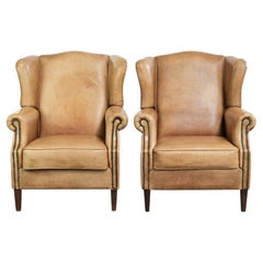 Juego de dos sillones de respaldo alto de piel de vaca clara con un estilo inglés atemporal