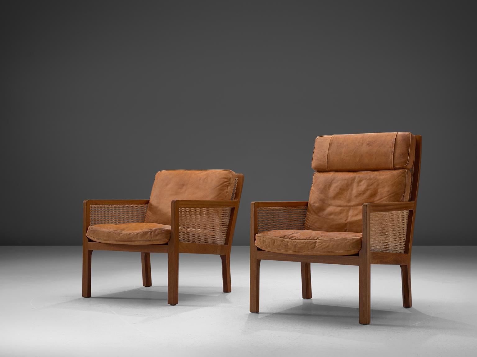 Bernt Petersen for Wørts Møbelsnedkeri, Adam & Eve lounge chairs, in mahogany, cane and leather, Denmark, 1964. 

Set of his and hers armchairs in mahogany and cane, upholstered with loose cushions in patinated cognac leather. The design is quite