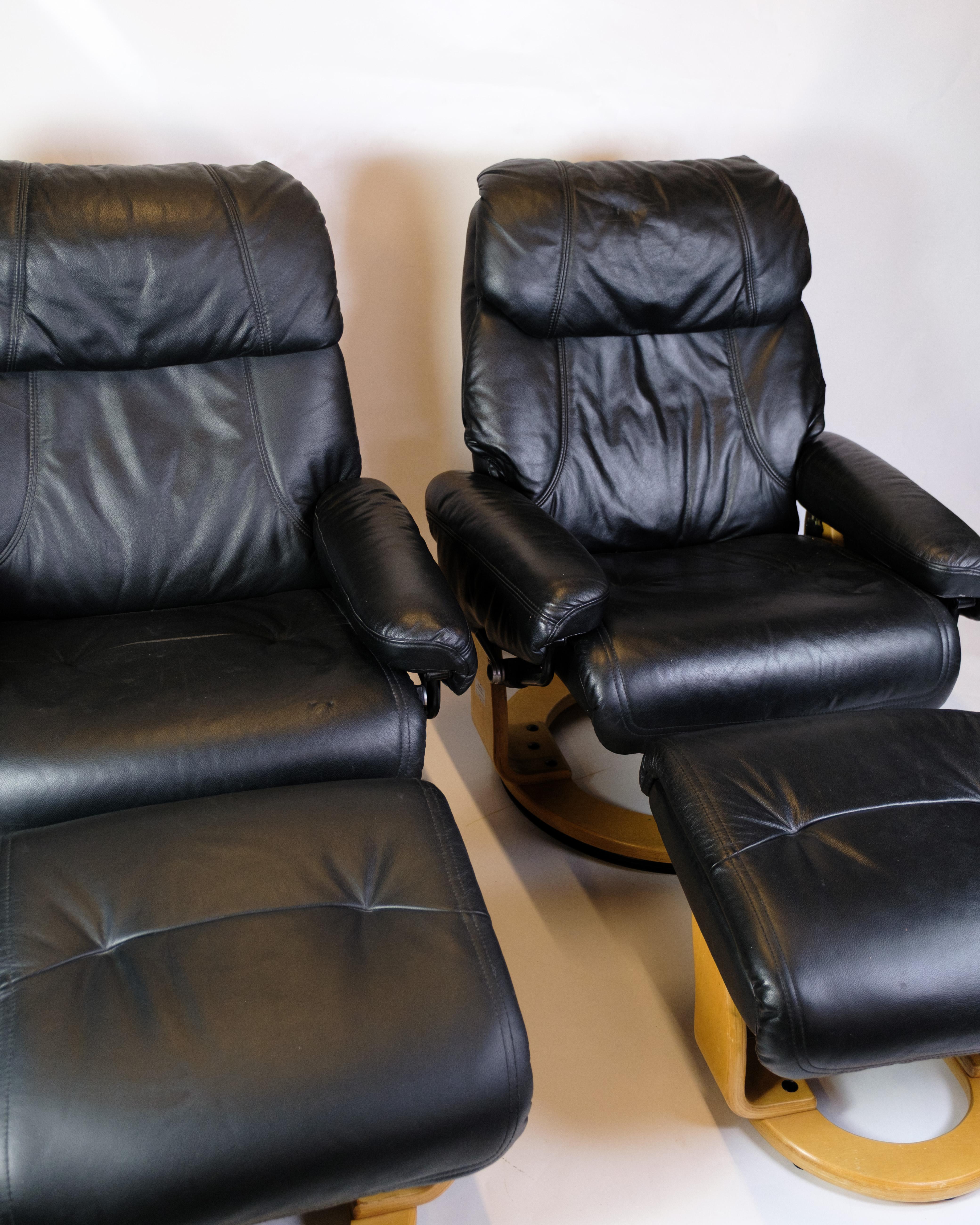 Set of two armchairs with footstool, upholstered in black leather with a frame in bent beech. An example of classic Scandinavian design with a focus on comfort and functionality.

The price is for one chair with footstool

Dimensions:
Armchair: