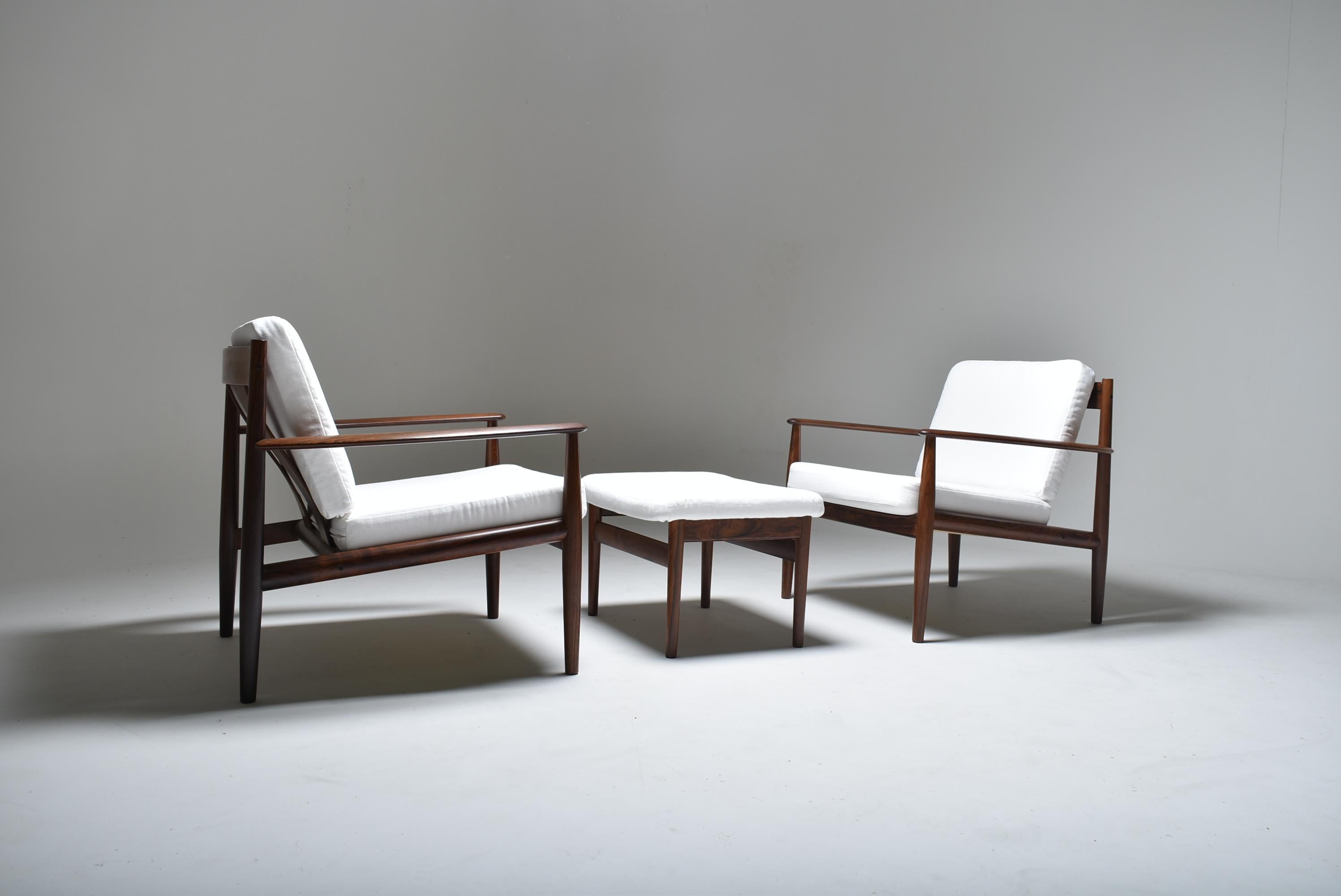 Set of two lounge chairs model 128 and one ottoman, designed by Grete Jalk, Denmark.
True classic due to the association of light and elegant design and perfectly balanced comfort. May be Grete Jalk's best design. 
Crafted according to high