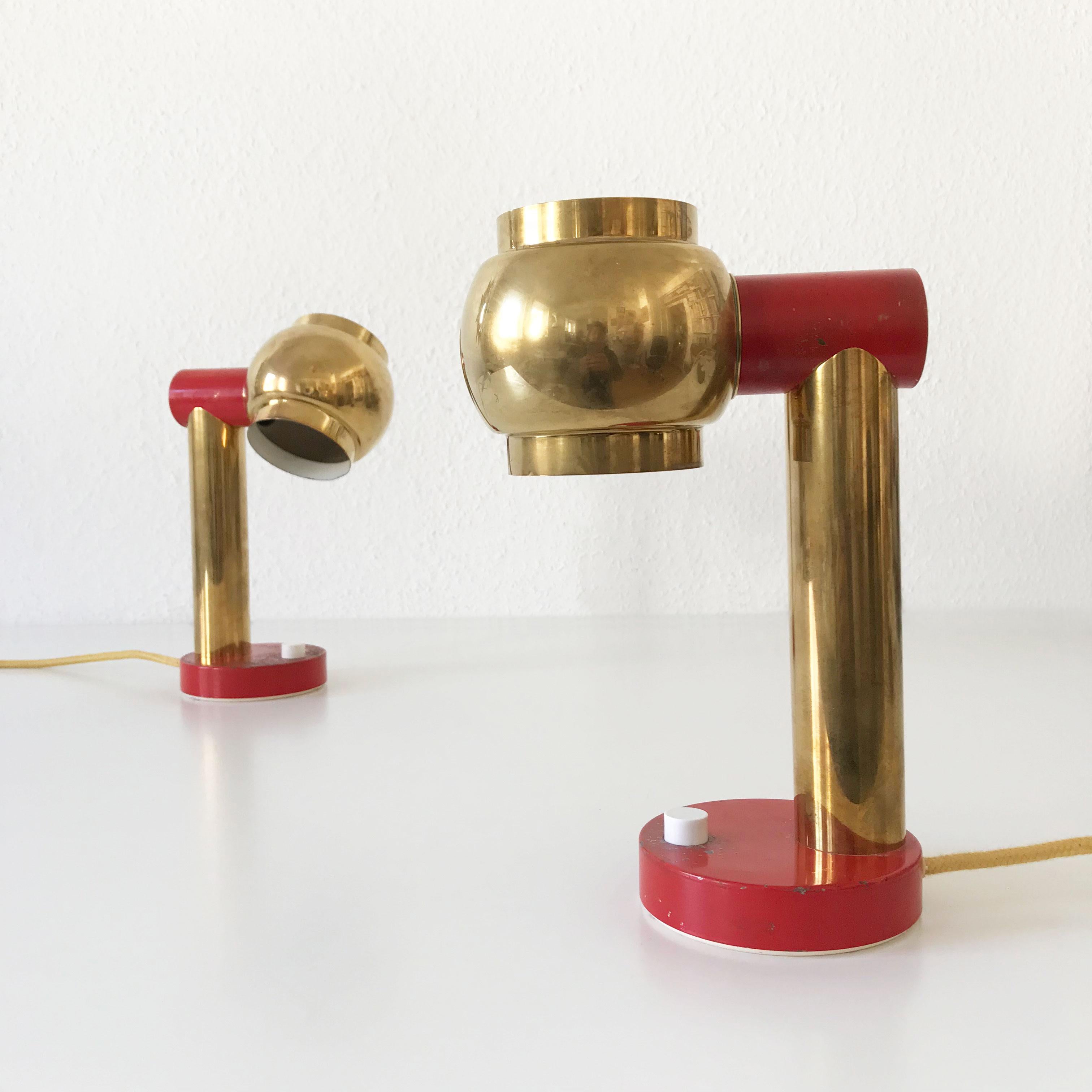 Set of Two Mid-Century Modern bedside table lamps with rotating shades. Designed and manufactured probably in Sweden, 1950s.
These identical table lamps are executed in brass; partly lacquered in dark red. The lamp shades are rotating.

Each lamp