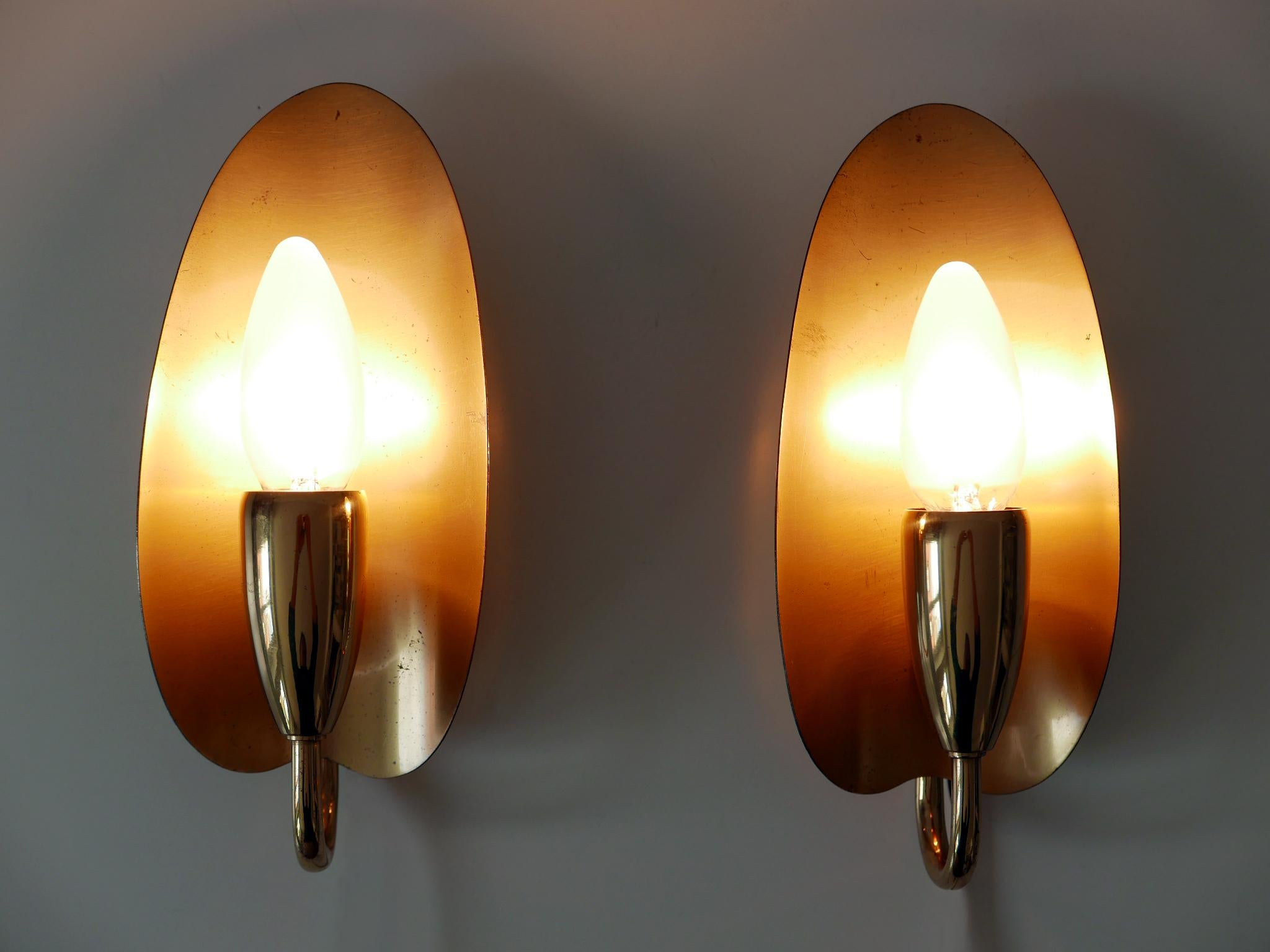 Set di due apparizioni o apparecchi da parete in stile Mid-Century Modern, eleganti e altamente decorativi. Progettato e prodotto in Germania, negli anni '50.

Realizzato in lamiera e tubi di ottone, ogni apparecchio è dotato di 1 portalampada a