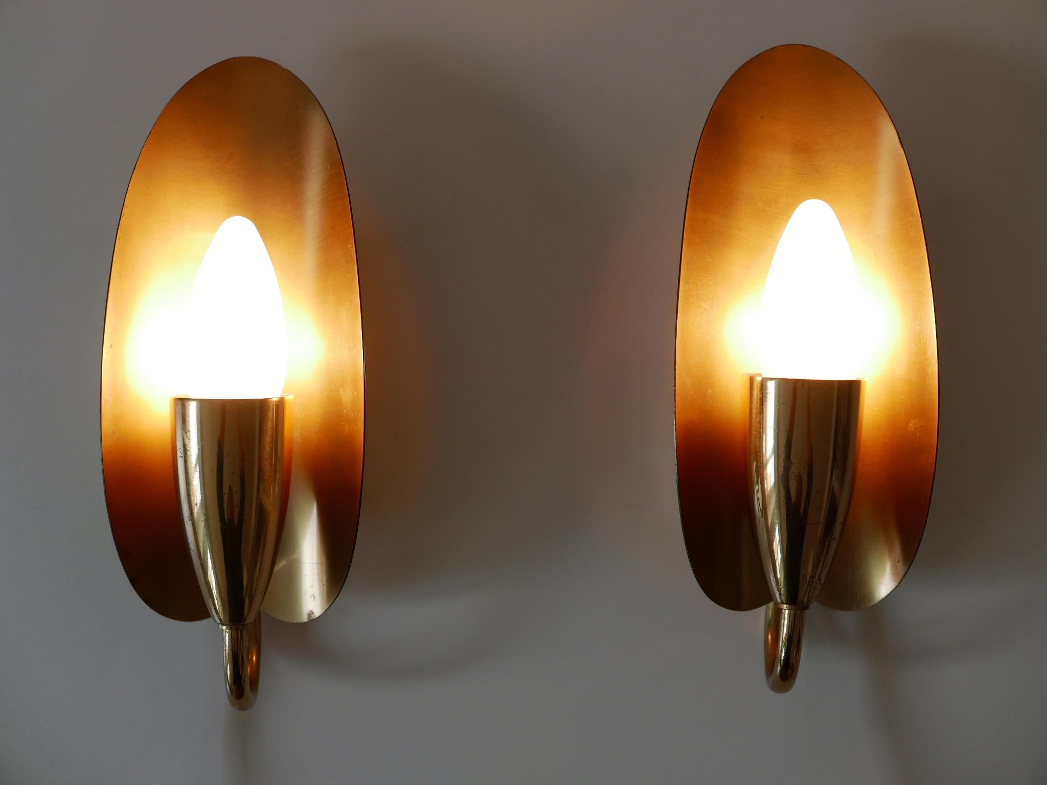 Set di due apparizioni o apparecchi da parete in stile Mid-Century Modern, eleganti e altamente decorativi. Progettato e prodotto in Germania, negli anni '50.

Realizzato in lamiera e tubi di ottone, ogni apparecchio è dotato di 1 portalampada a