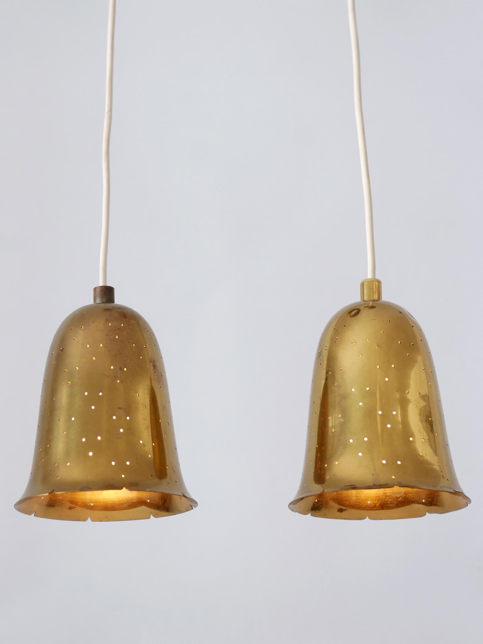 Set of two lovely and highly decorative Mid-Century Modern perforated brass pendant lamps. Manufactured by Boréns Borås, Sweden 1950s.

Executed in perforated brass, the pendant lamps are executed with 1 x E127 / E26 Edison screw fit bulb sockets,
