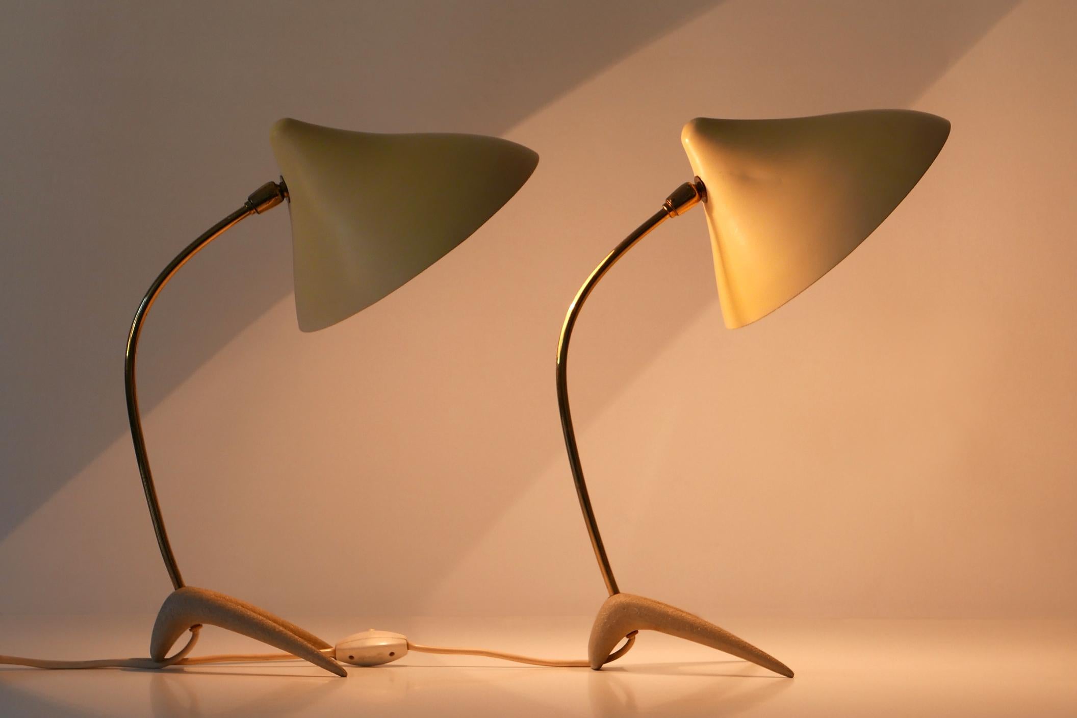 Set of two rare and lovely Mid-Century Modern table lamps with adjustable lamp shades. Designed by Louis Kalff for Gebrüder Cosack, 1950s, Neheim-Hüsten, Germany

Executed in brass tube, enameled aluminum and cast metal, each lamp comes with 1 x 27