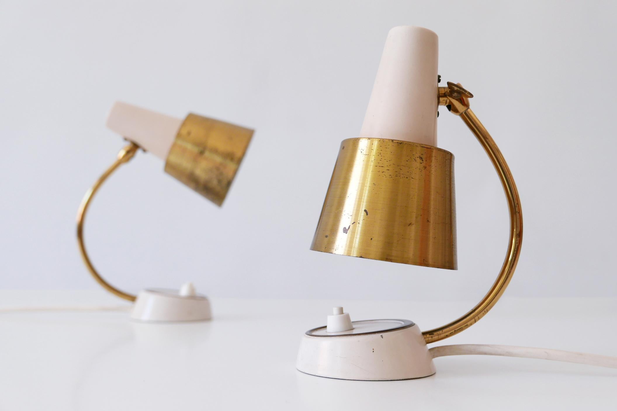 Set of two lovely Mid-Century Modern bedside table lamps or wall lights. Manufactured in 1950s, Germany. They can be used as well bedside table lamps as wall lamps.

Executed in brass sheet and tube, each lamp comes with 1 x E14 / E12 Edison screw