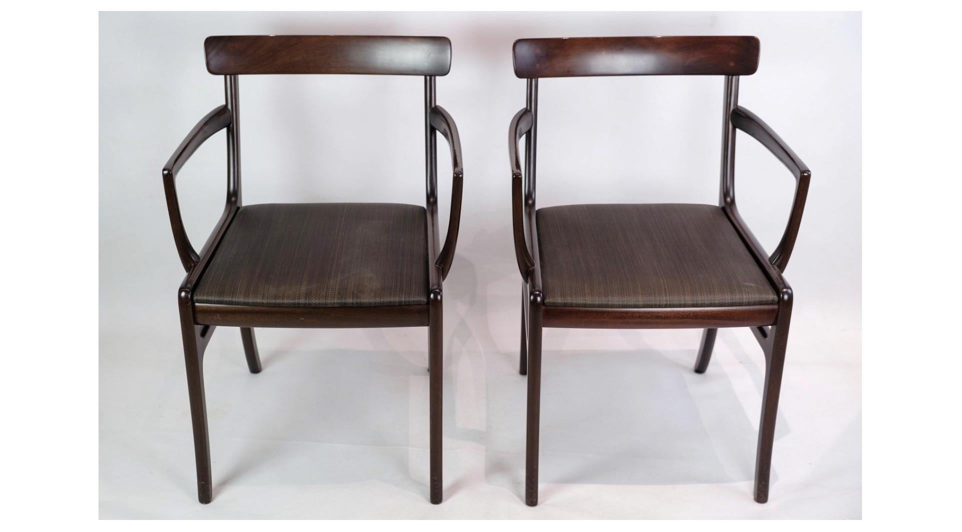 A pair of Rungstedlund armchairs, made of mahogany and covered in black leather, is a brilliant example of Ole Wanscher's timeless design, combining aesthetics and functionality in a sublime way.

Ole Wanscher, one of the most important Danish