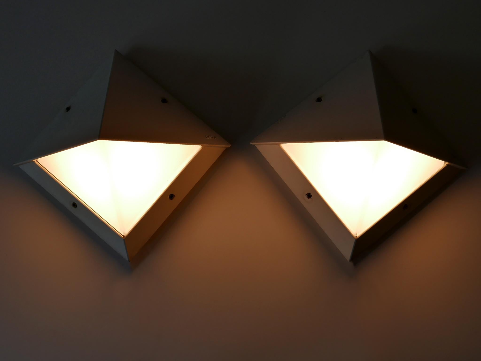 Set aus zwei eleganten modernistischen Wandlampen oder Wandleuchtern für den Außenbereich. Entworfen und hergestellt von BEGA, Deutschland, 1980er Jahre.

Jede Lampe ist aus weiß emailliertem Aluminiumguss und Glas gefertigt, benötigt 1 x E27 /