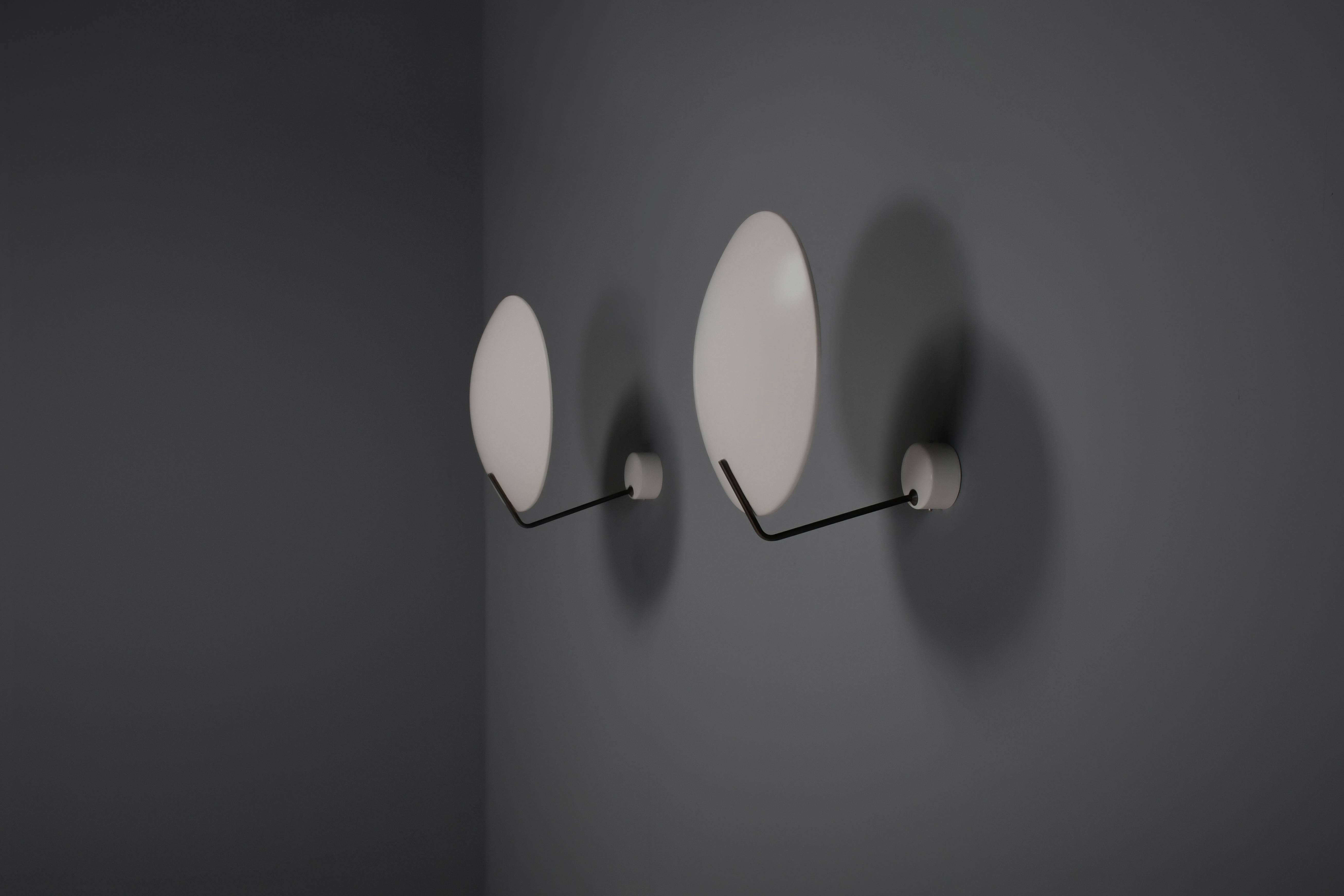 Elegantes lampes murales modèle 232 en très bon état.

Conçu par Bruno Gatta en 1962.

Fabriqué par Stilnovo Italie

Les lampes ont un abat-jour en métal laqué blanc qui est fixé à une plaque murale par un bras noir/laiton.

Chaque lampe possède