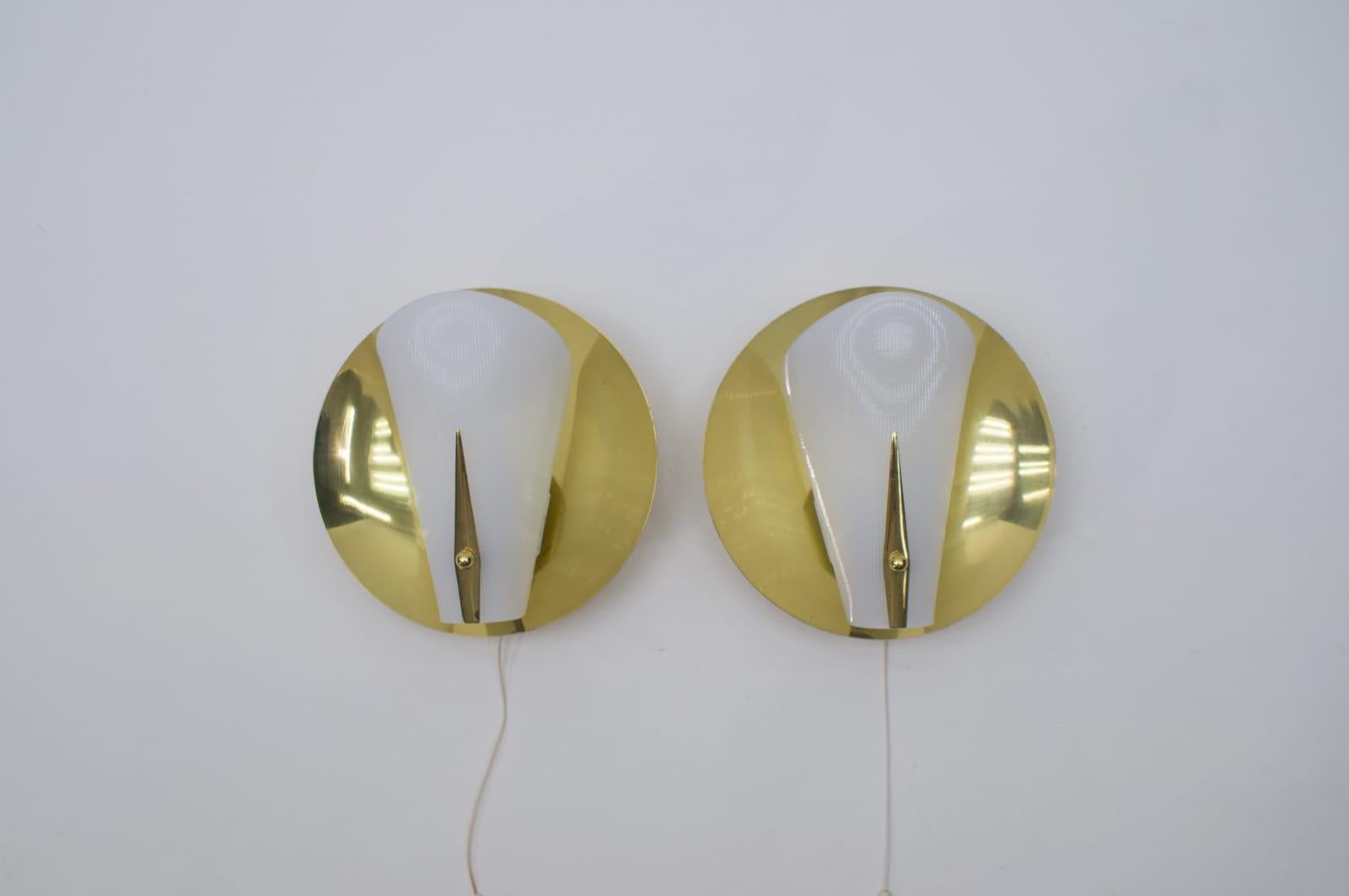 Set of two rare and beautiful Mid-Century Modern brass wall lamps or sconces. 

The lamps are executed in white acrylic glass and brass. 

Each lamp needs 1 x E14 Edison screw fit bulb. They are wired, in working condition and run both on 110 /