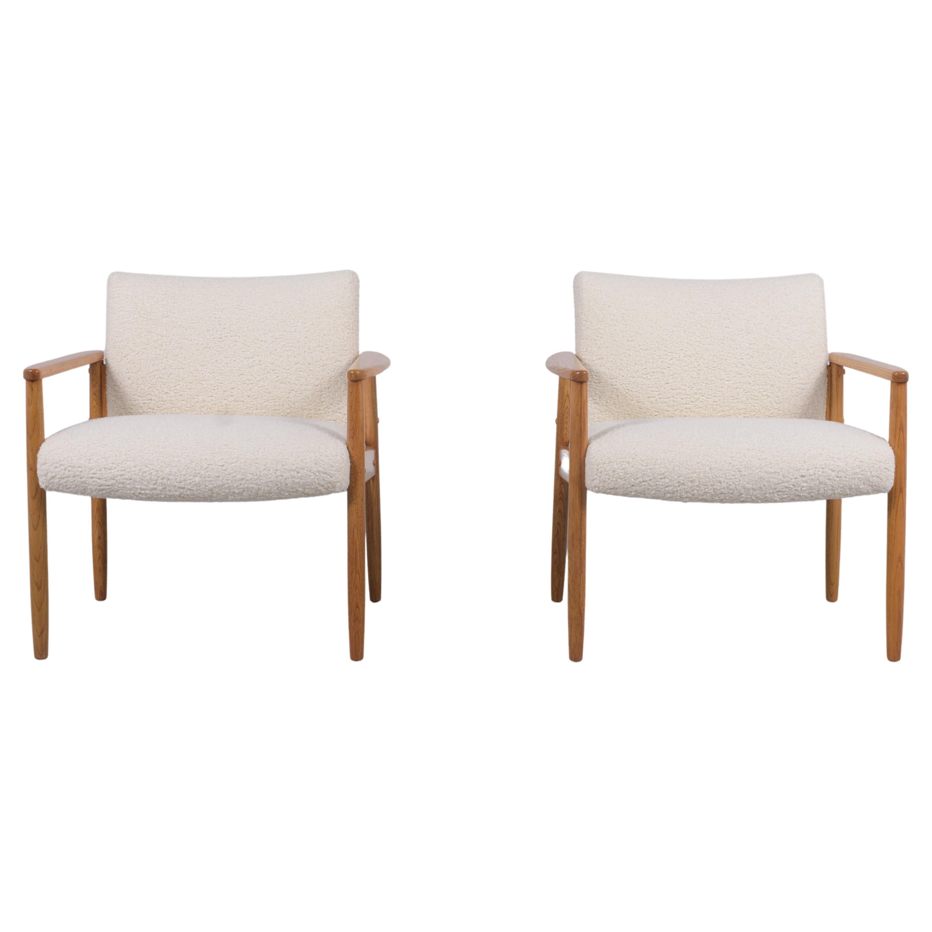 Embrace timeless charm with our pair of mid-century oak armchairs, skillfully restored and crafted to perfection by our dedicated team of craftsmen. Boasting a pristine condition, these vintage lounge chairs shine with their streamlined design,