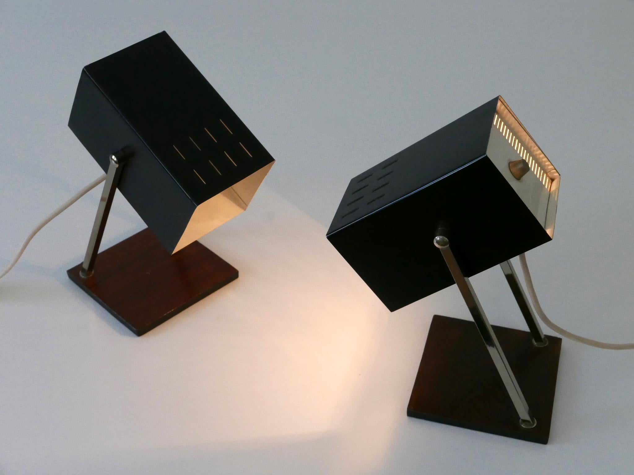 Ensemble de deux rares et élégantes lampes de chevet cubiques de style moderne du milieu du siècle. Fabriqué par Kaiser Leuchten, 1960, Allemagne

Réalisée en partie en métal peint en noir et en placage de teck, chaque lampe est livrée avec un