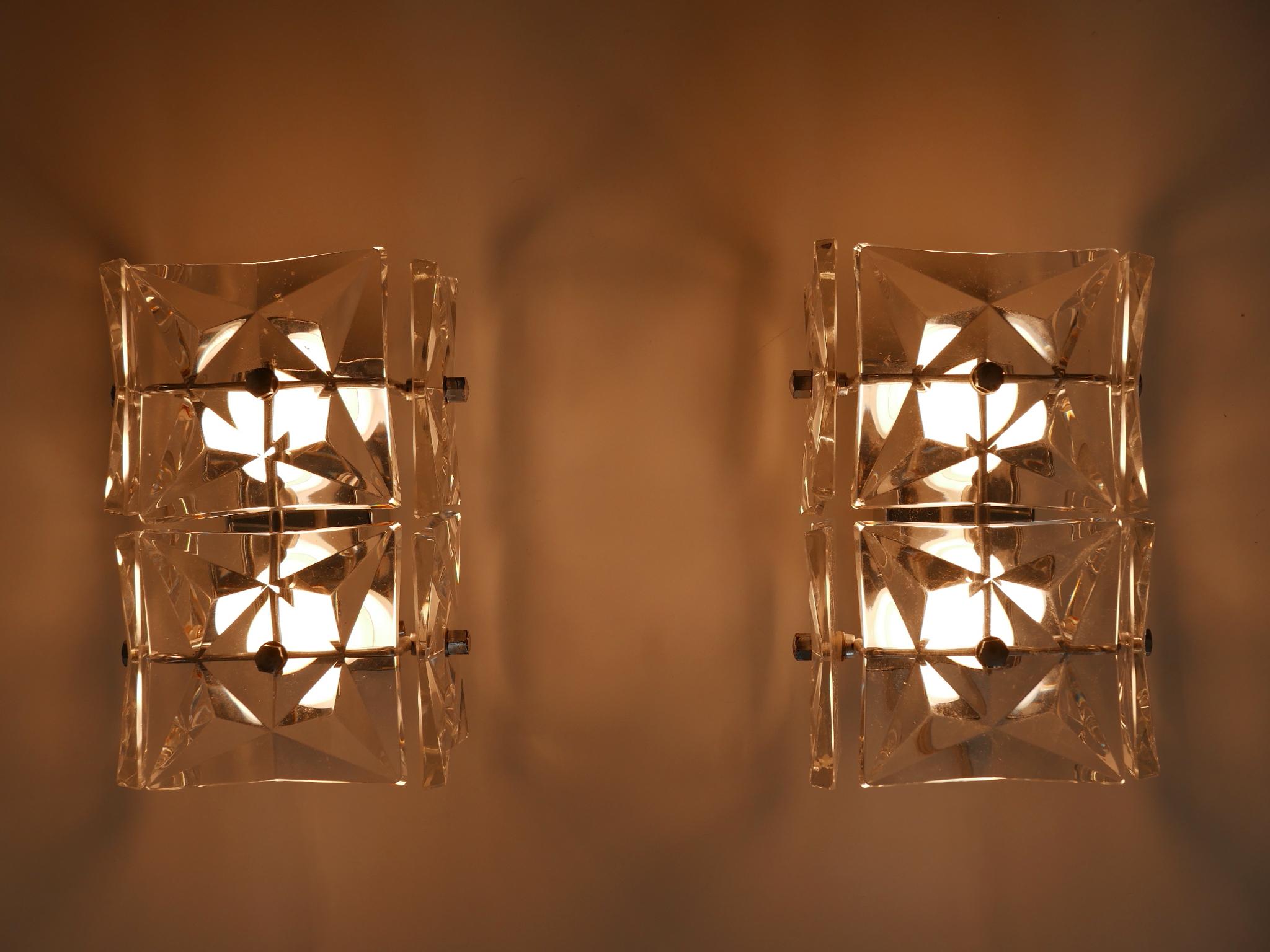 Set di due bellissime applique o lampade da parete in vetro di cristallo in stile Mid-Century Modern. Prodotto da Kinkeldey, 1960, Germania.

Realizzata in vetro cristallo e ottone cromato, ogni lampada necessita di 2 lampadine a vite E14 / E12