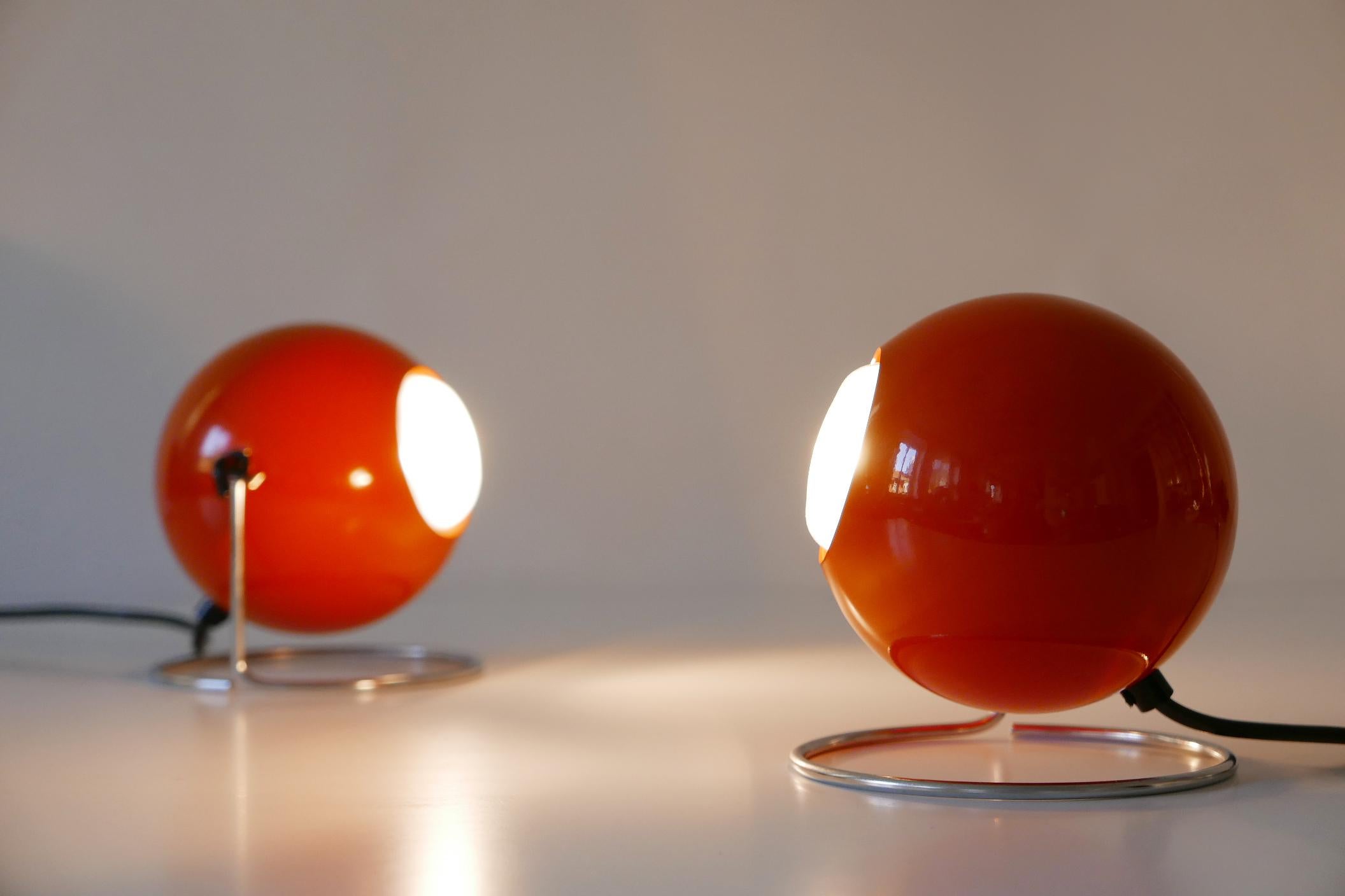 Set of two extremely rare, lovely Mid-Century Modern 'Eye' table lamps. Designed and manufactured by ERCO Leuchten, 1960s-1970s, Germany. Manufacturers label inside the lamp shades (see the last image).

Executed in red-orange enameled aluminium and
